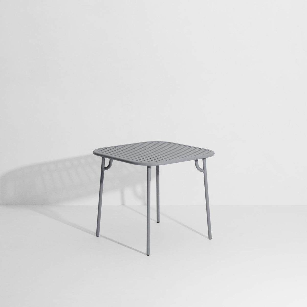 Week-End Tisch Small von Petite Friture in Gold: ovale Tischplatte mit horizontalen Lamellen-Streifen, Gestell aus mattiertem Aluminium.
