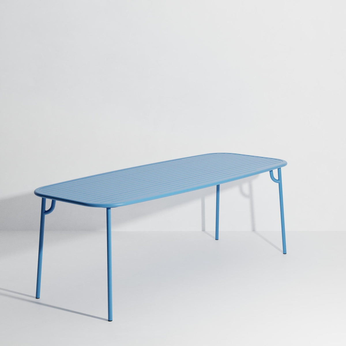 Week-End Tisch Large von Petite Friture in Pigeon Blue: ovaler Gartentisch aus Aluminium mit gerahmten, streifenartigen Lamellen.
