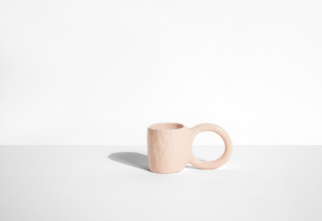 Keramiktasse Donut in Pistazie mit glasierter Oberfläche und donutförmigem Henkel, mittlere Grösse, handwerklicher Look, auf hellem Hintergrund.