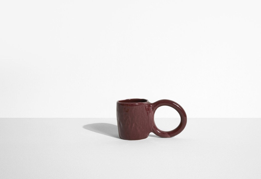 Keramiktasse Donut in Pistazie mit glasierter Oberfläche und donutförmigem Henkel, mittlere Grösse, handwerklicher Look, auf hellem Hintergrund.