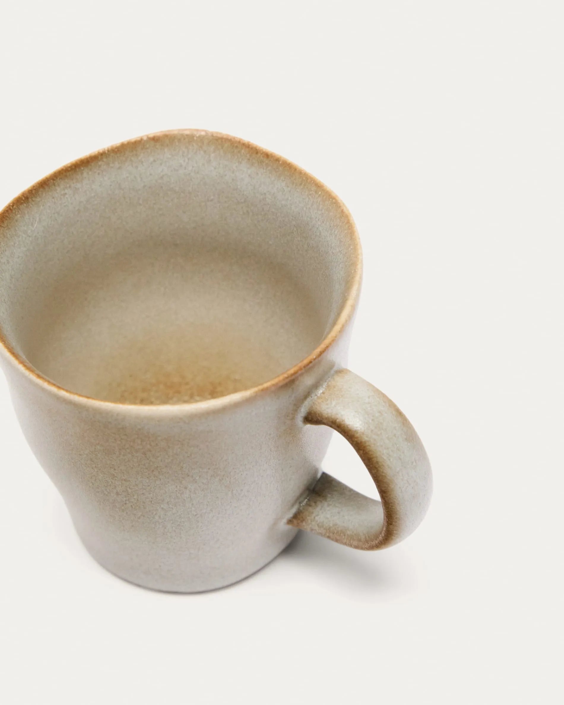 Elegante weiße Keramiktasse von Kave Home, ideal für Kaffee oder Tee, vereint traditionelles Handwerk mit modernem Design.