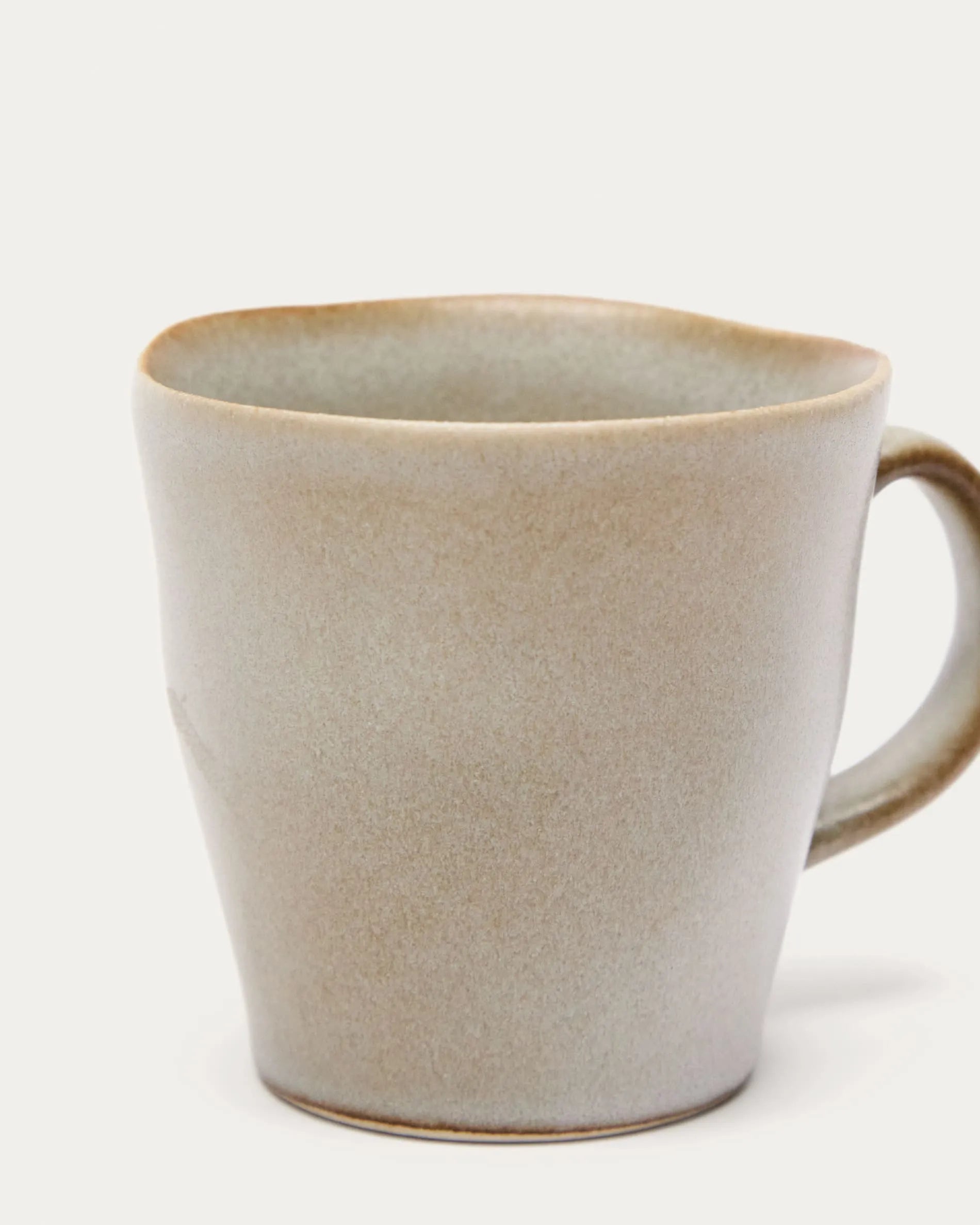 Elegante weiße Keramiktasse von Kave Home, ideal für Kaffee oder Tee, vereint traditionelles Handwerk mit modernem Design.