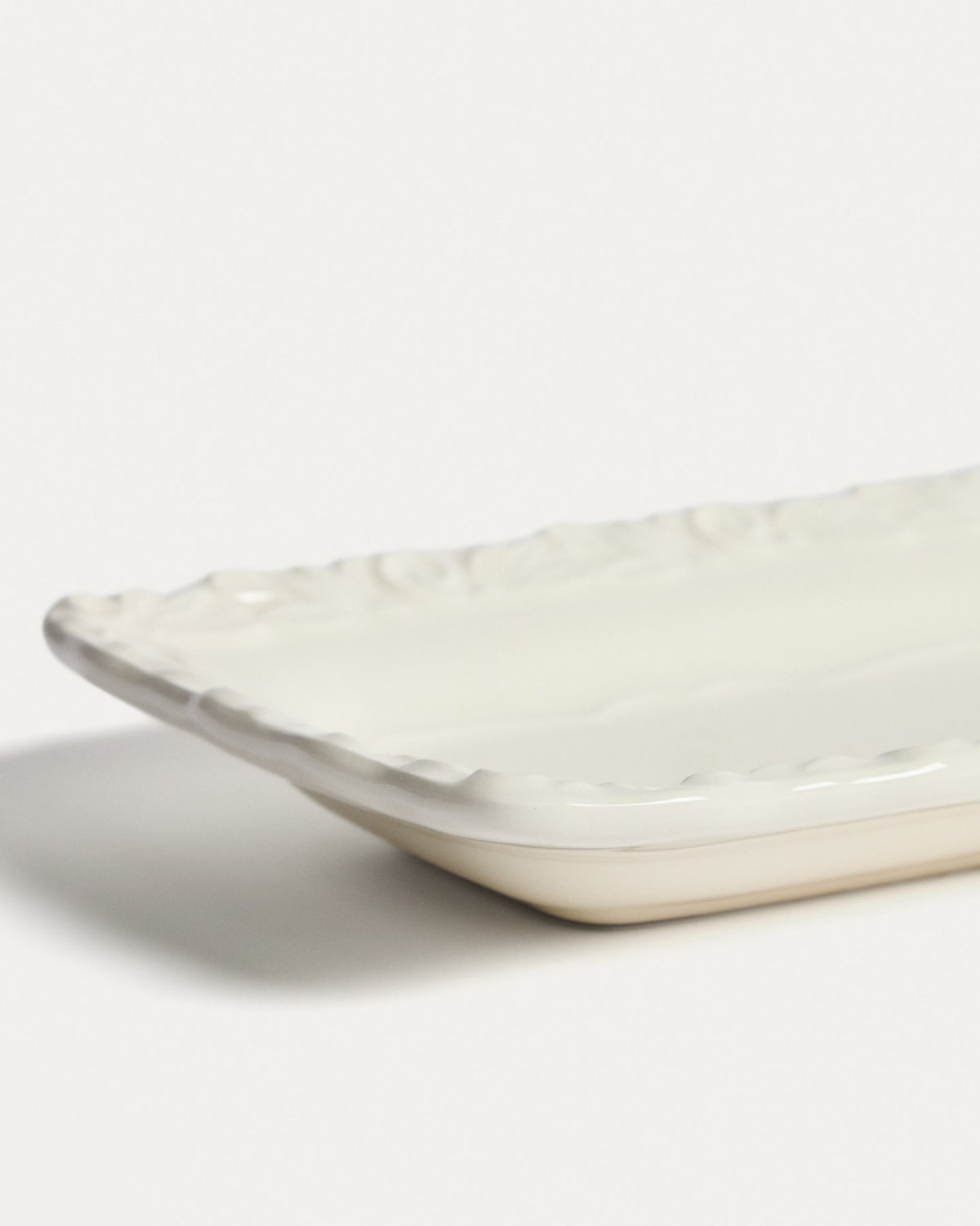 Keramik-Tablett in Beige und Weiss mit dezentem Reliefmuster, glatte Oberfläche, misst 34 x 30 x 10 cm.