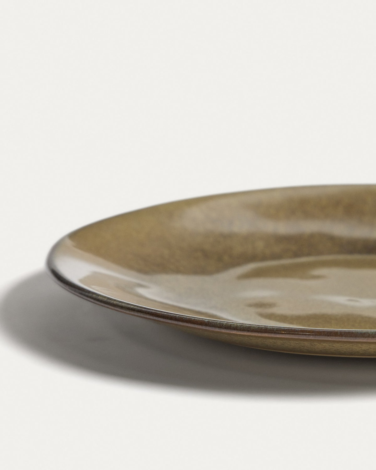 Runder Dessertteller aus glänzender Keramik in moosgrün/dunkelgrün, Durchmesser 27 cm, Höhe 9.5 cm, mit reaktiver Glasur und leichten Farbvariationen.