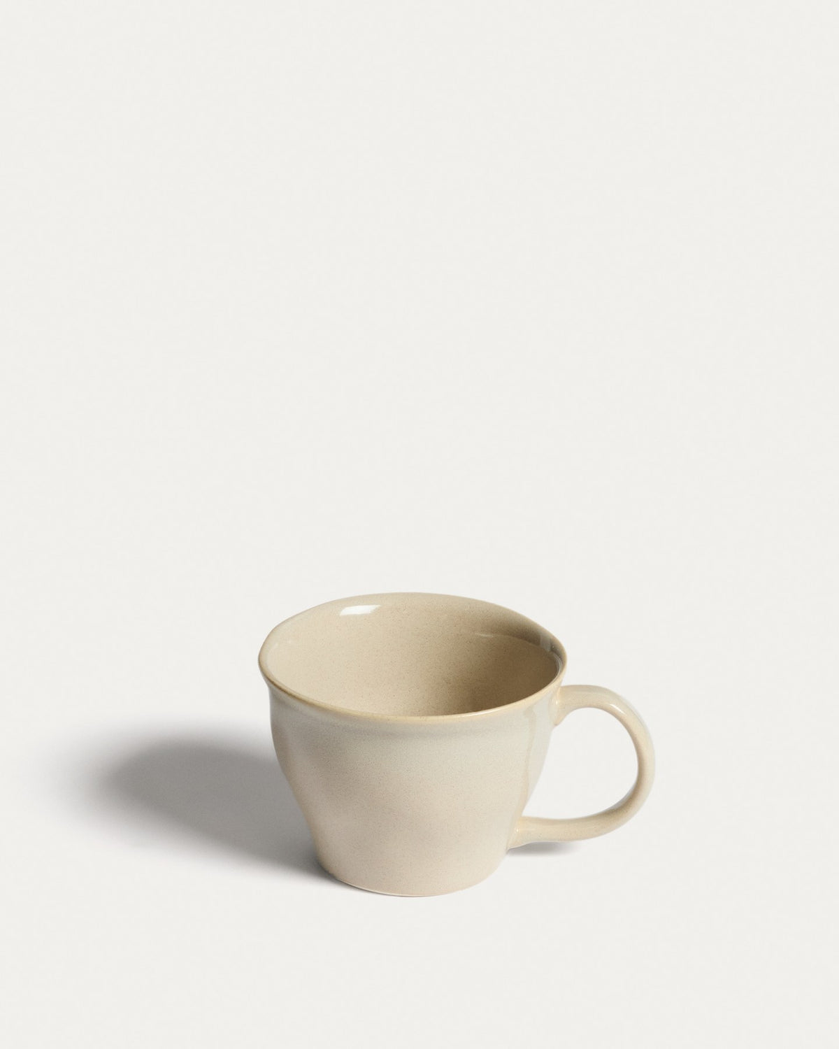 Elfenbeinfarbene Tasse aus Keramik mit glänzender Oberfläche, schlichter Form, Teil der Aderno-Kollektion von Kave Home.