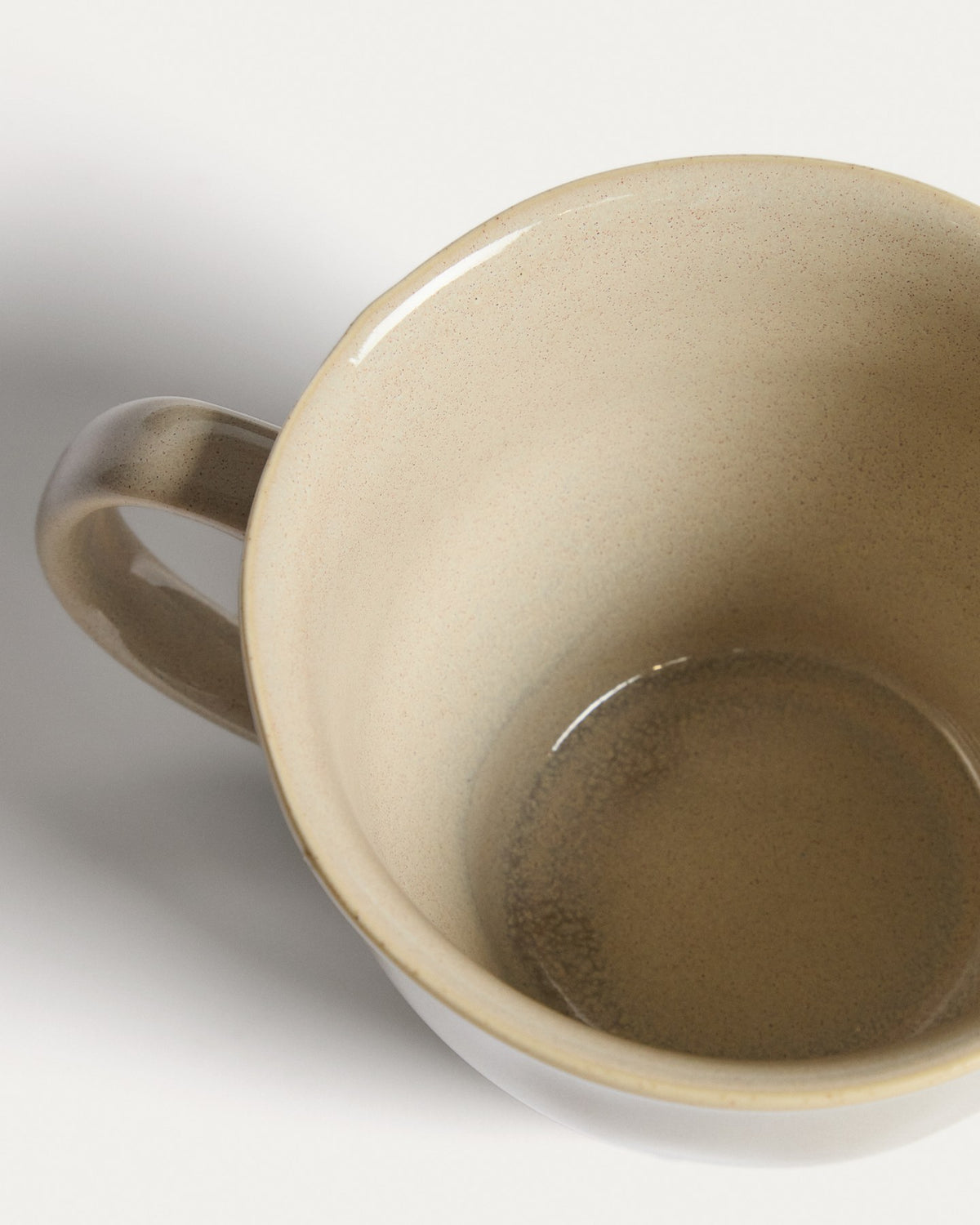 Elfenbeinfarbene Tasse aus Keramik mit glänzender Oberfläche, schlichter Form, Teil der Aderno-Kollektion von Kave Home.