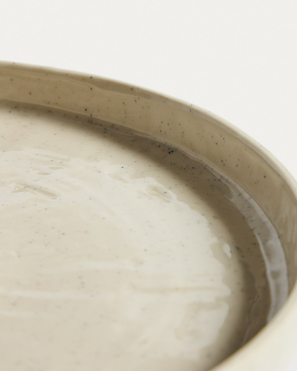 Flacher Teller aus Keramik in den Farben Weiss und Beige (Écru), runde Form mit reaktiver Glasur, Durchmesser 27.5 cm.