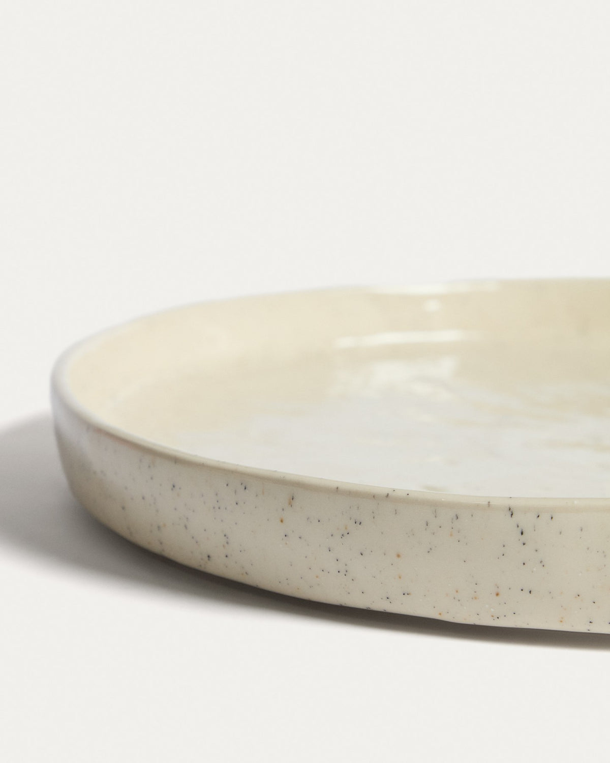 Flacher Teller aus Keramik in den Farben Weiss und Beige (Écru), runde Form mit reaktiver Glasur, Durchmesser 27.5 cm.