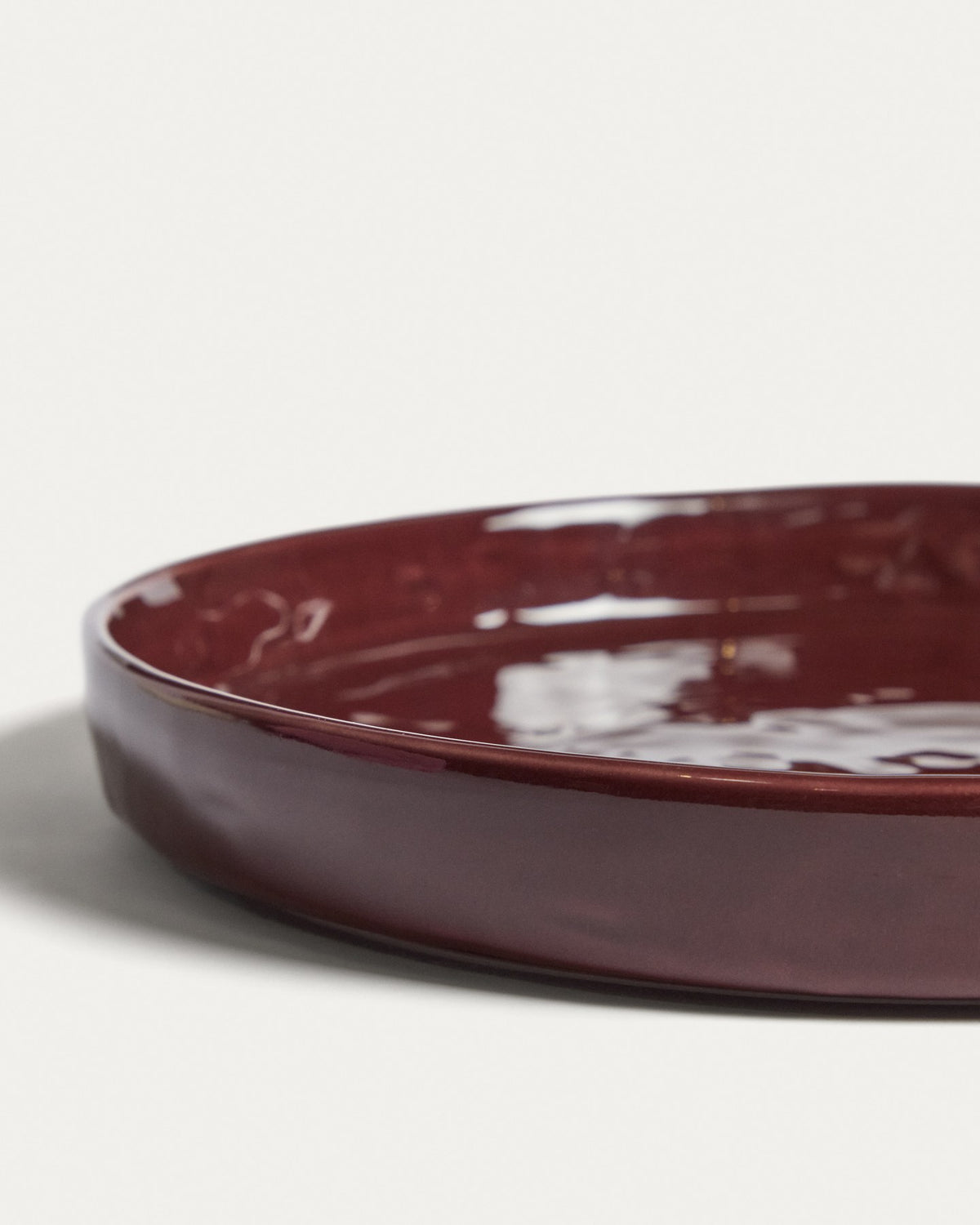 Runder Dessertteller aus glänzender Keramik in burgunderroter Farbe mit leicht variierender Glasuroberfläche, Kave Home Kollektion Daner.