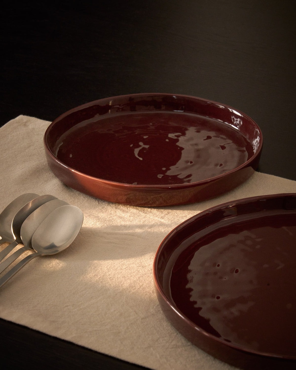 Runder Dessertteller aus glänzender Keramik in burgunderroter Farbe mit leicht variierender Glasuroberfläche, Kave Home Kollektion Daner.