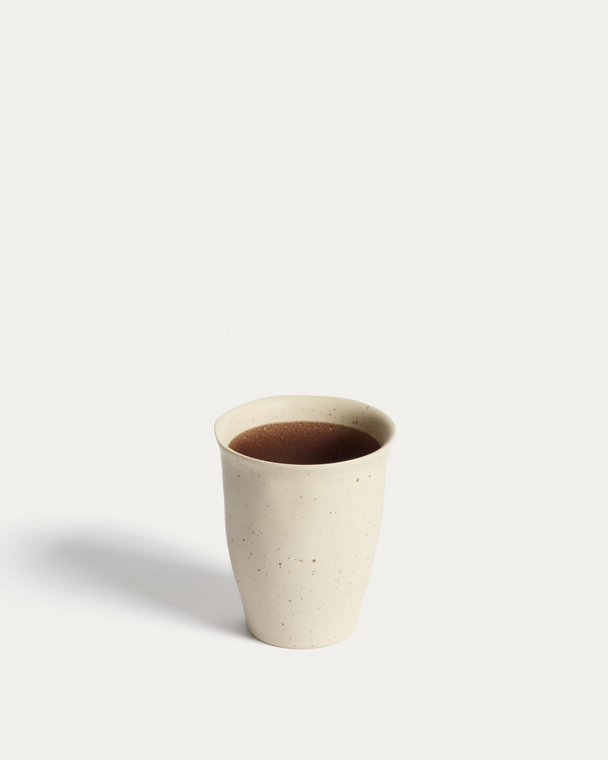 Keramiktasse Nale in Beige mit braunem Boden, glänzende Oberfläche, schlichte runde Form, Durchmesser 9 cm, Höhe 11 cm.
