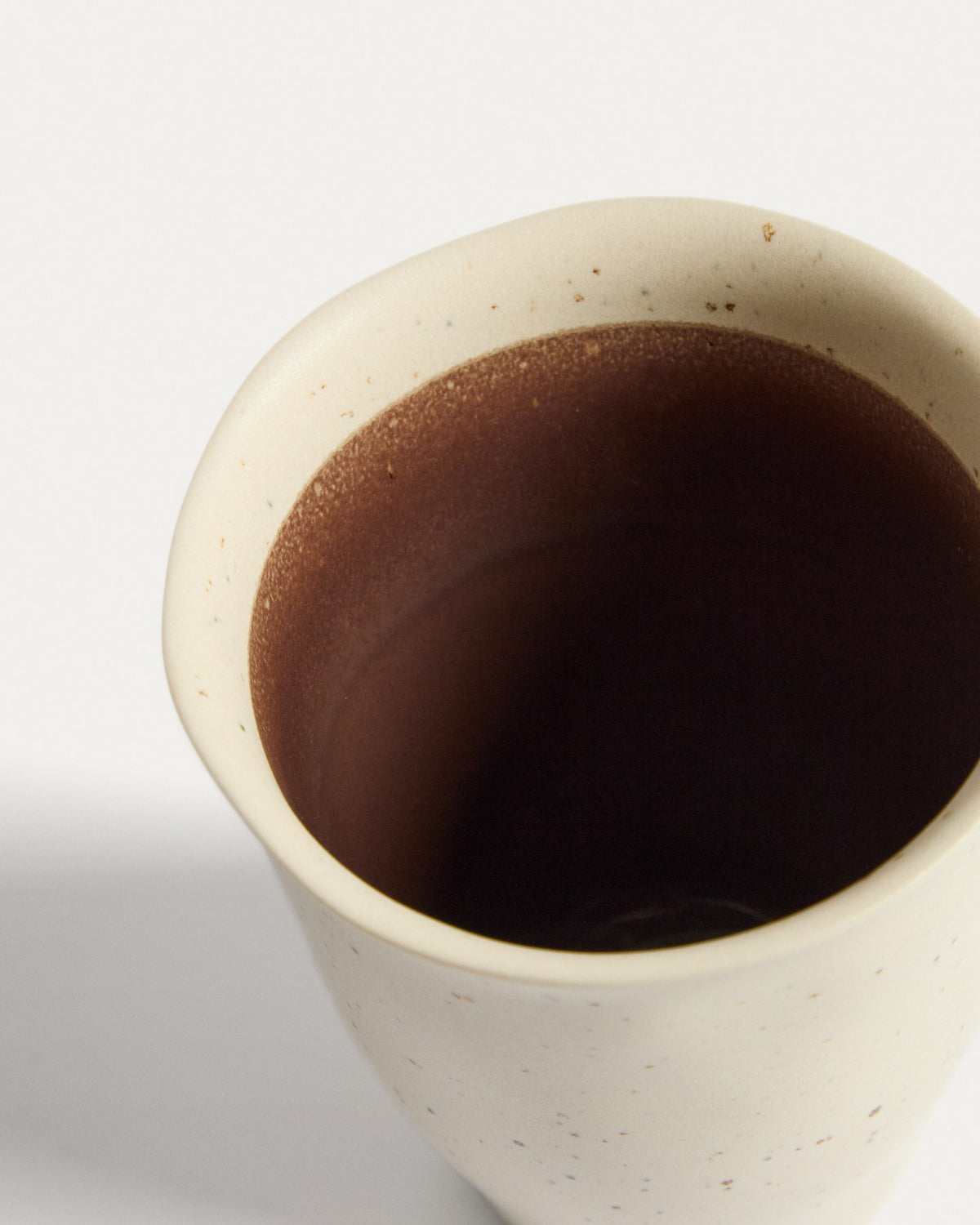 Keramiktasse Nale in Beige mit braunem Boden, glänzende Oberfläche, schlichte runde Form, Durchmesser 9 cm, Höhe 11 cm.