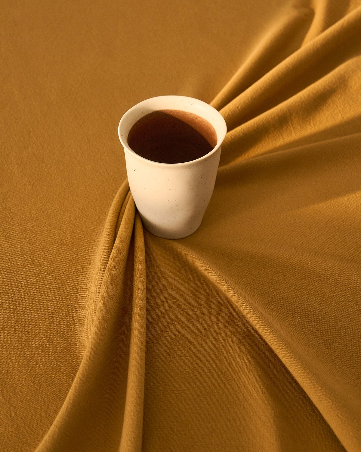 Keramiktasse Nale in Beige mit braunem Boden, glänzende Oberfläche, schlichte runde Form, Durchmesser 9 cm, Höhe 11 cm.