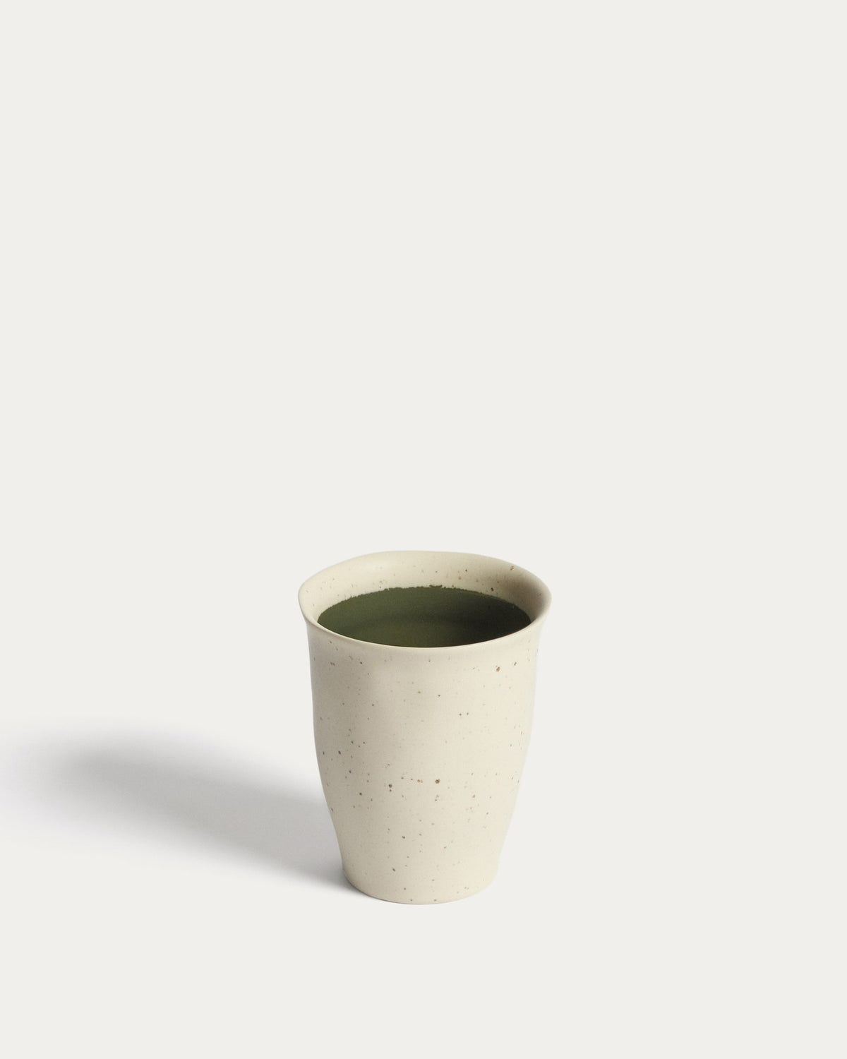Keramiktasse Nale von Kave Home in Beige mit glänzendem grünem Boden, schlichte Form, Durchmesser 9 cm, Höhe 11 cm.