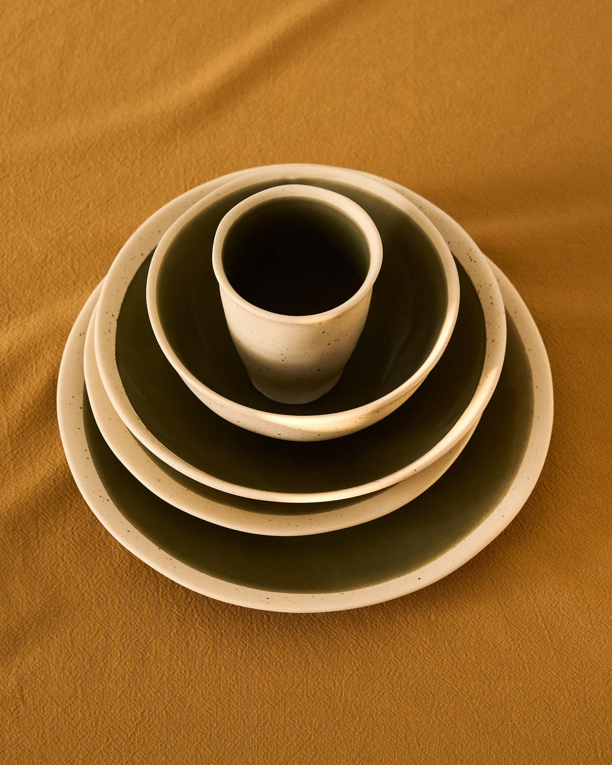 Keramiktasse Nale von Kave Home in Beige mit glänzendem grünem Boden, schlichte Form, Durchmesser 9 cm, Höhe 11 cm.