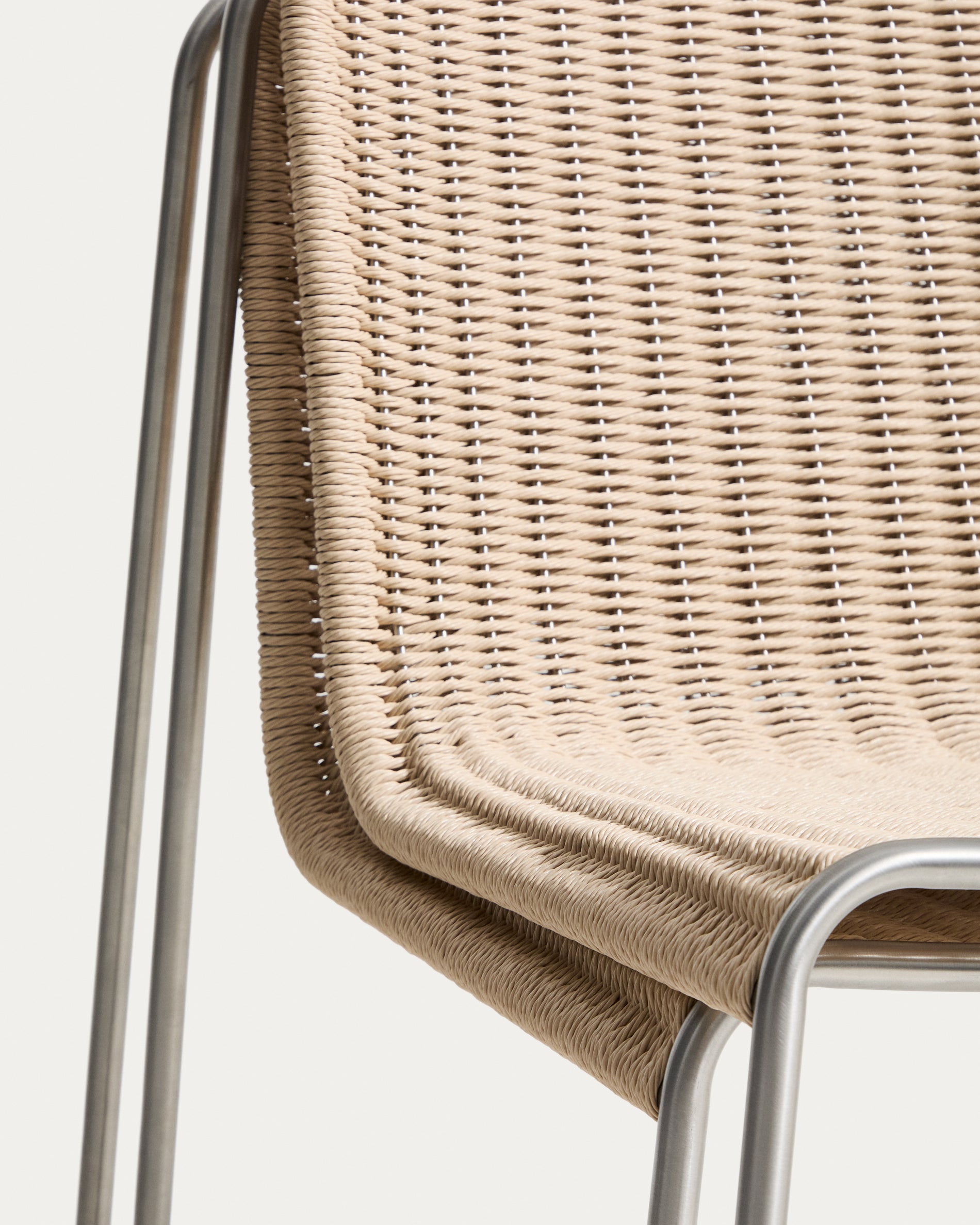 Bequemer Stapelsessel Tavari in sanftem Beige, aus langlebigem Synthetikseil und gebürstetem Edelstahl, perfekt für den Außenbereich.