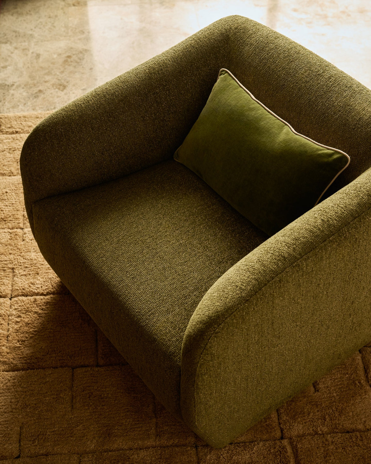 Olivgrüner Sessel Milare mit Chenille-Bezug, schwarzen Kunststoffgleitern und geschwungener Rückenlehne, Sitzbreite 53 cm.