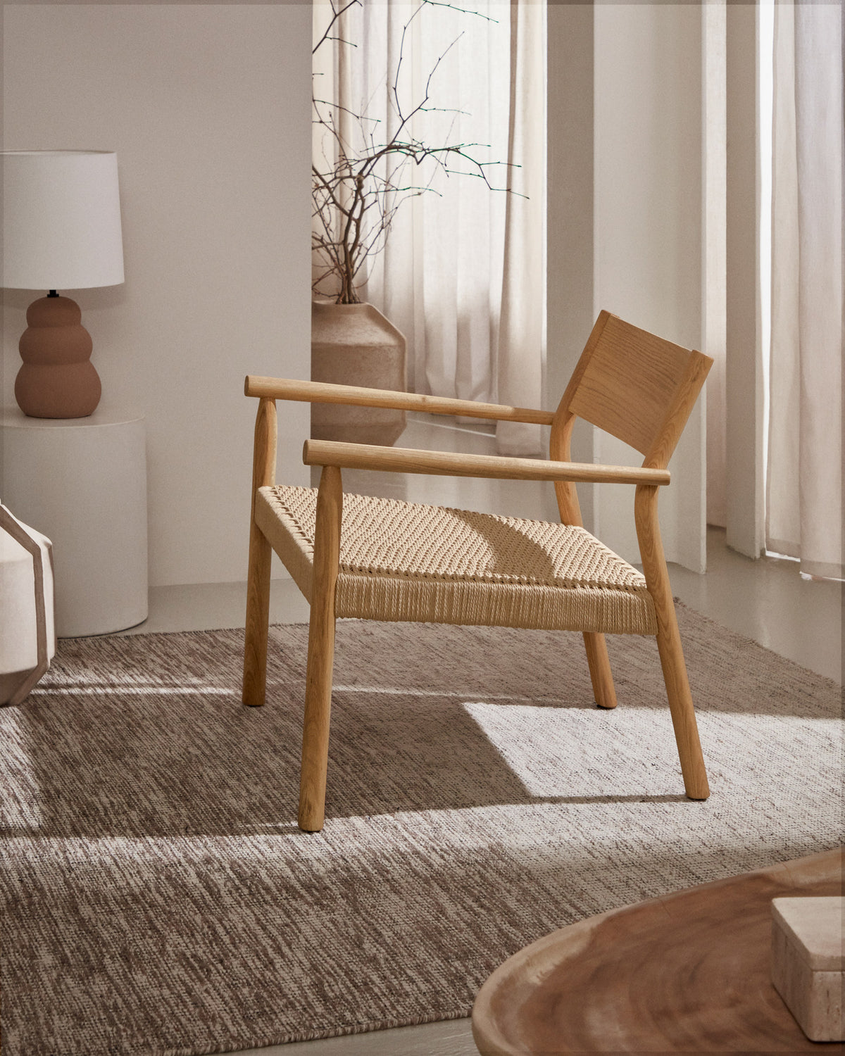 Yalia Sessel aus massivem Eichenholz mit naturfarbenem Finish und Sitzfläche aus Papierseil FSC Mix Credit in Natur präsentiert im Onlineshop von KAQTU Design AG. Outdoor-Sessel mit Armlehnen ist von Kave Home