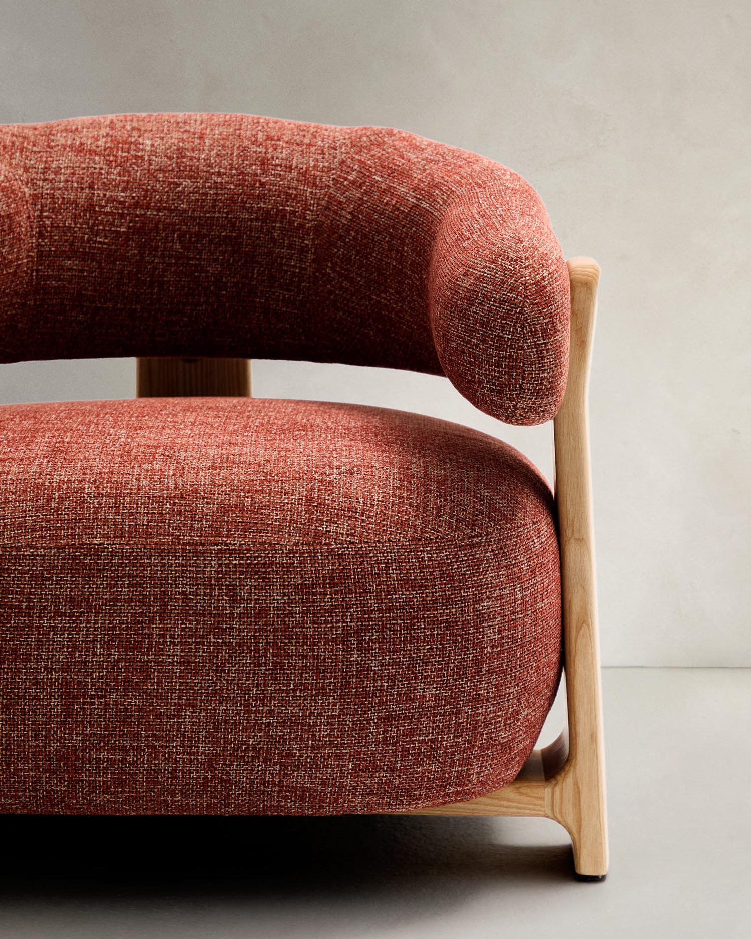 Stilvoller Sessel in terrakottafarbener Chenille mit massiven Eschenholzbeinen. Ideal für ein modernes, einladendes Wohnambiente.