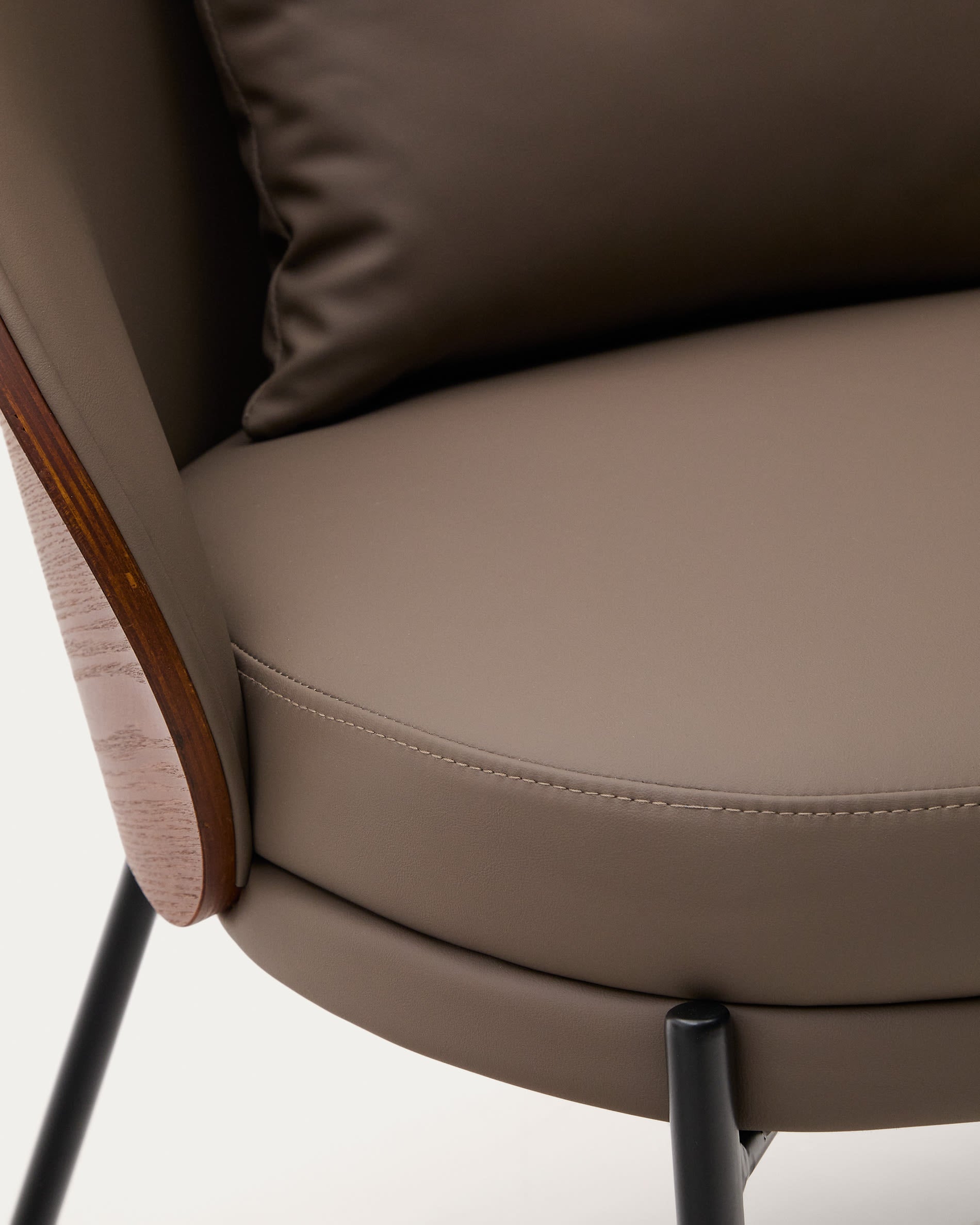 Eamy Sessel: Stilvolles Design mit braunem Kunstleder, Nussbaum-Eschenfurnier und schwarzem Metall – ideal für moderne Wohnräume.