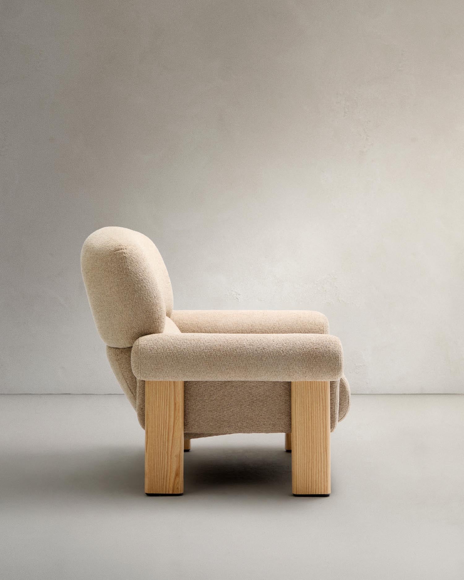 Armchair nema made of beige chenille and legs made of solid ash wood with natural