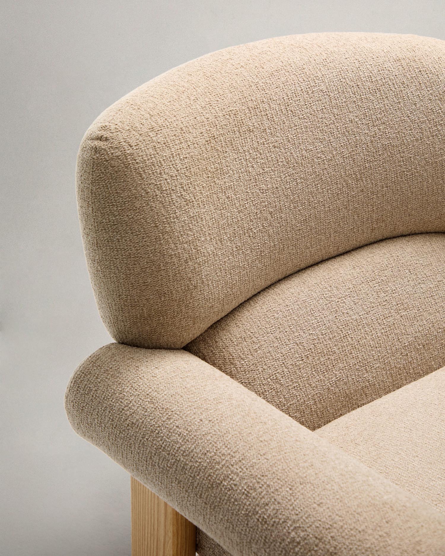 Armchair nema made of beige chenille and legs made of solid ash wood with natural