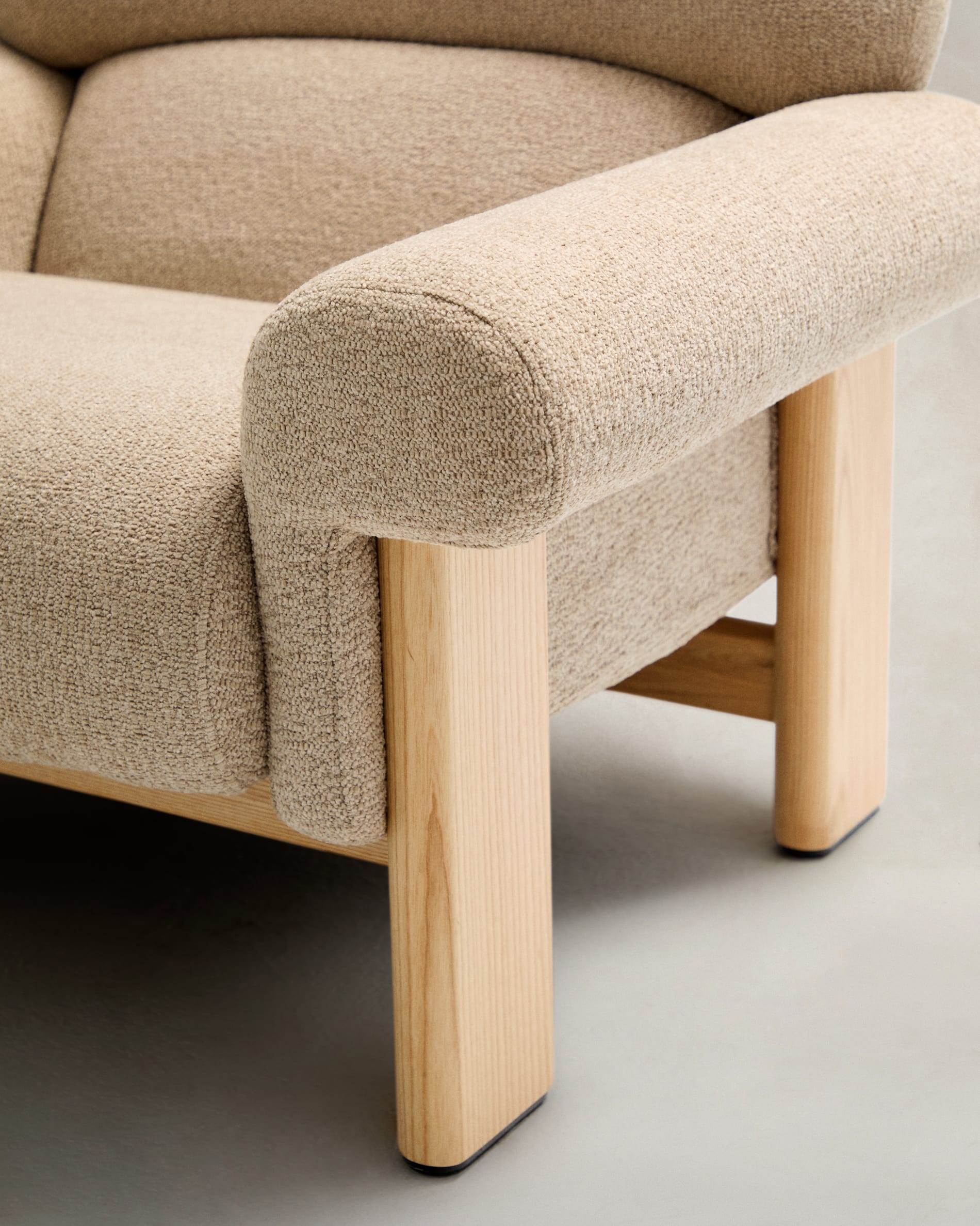 Armchair nema made of beige chenille and legs made of solid ash wood with natural