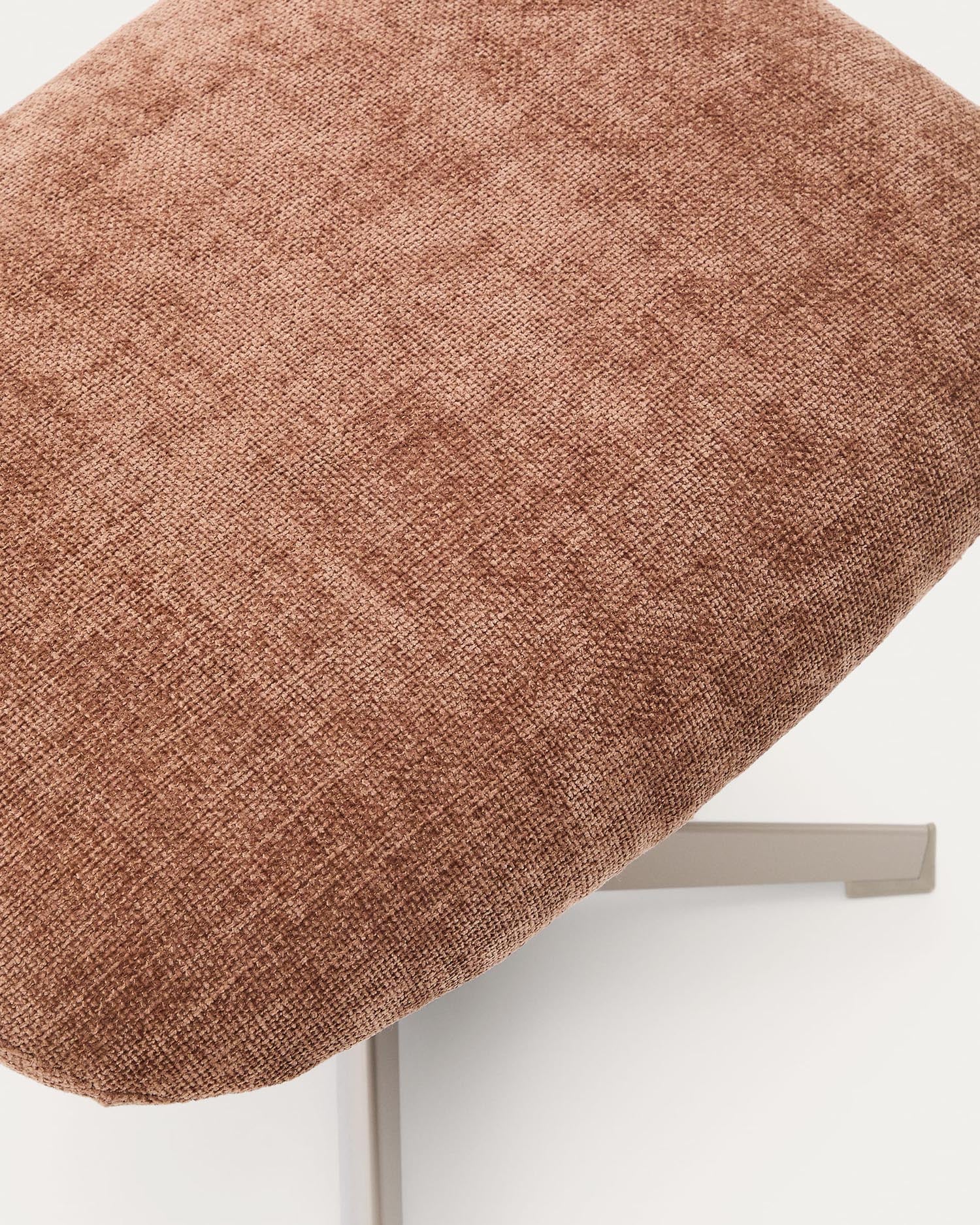 Die Fussstütze Teryl kombiniert elegantes hellbraunes Chenille mit stabilen grauen Metallbeinen und bietet stilvollen Komfort für jedes Zuhause.