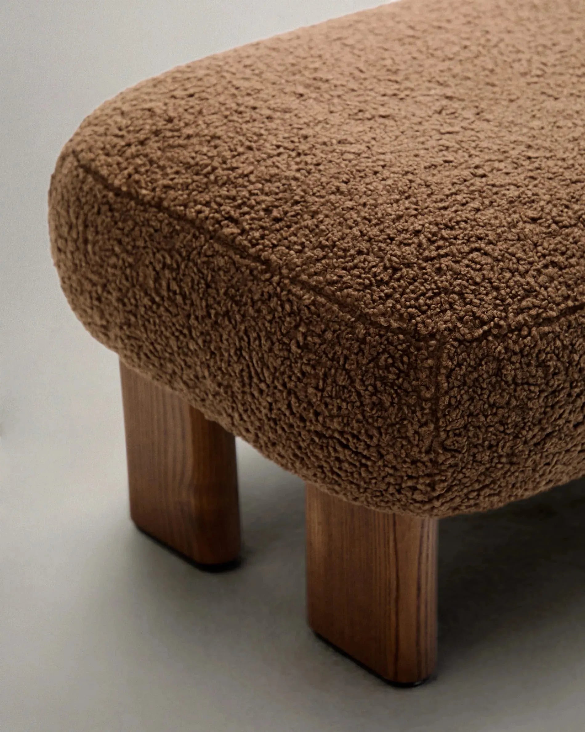 Elegante Fußstütze mit taupefarbenem Bouclé-Bezug, Beinen aus Eschenholz mit Walnuss-Finish, FSC-zertifiziert, Maße: 65x55,4 cm.