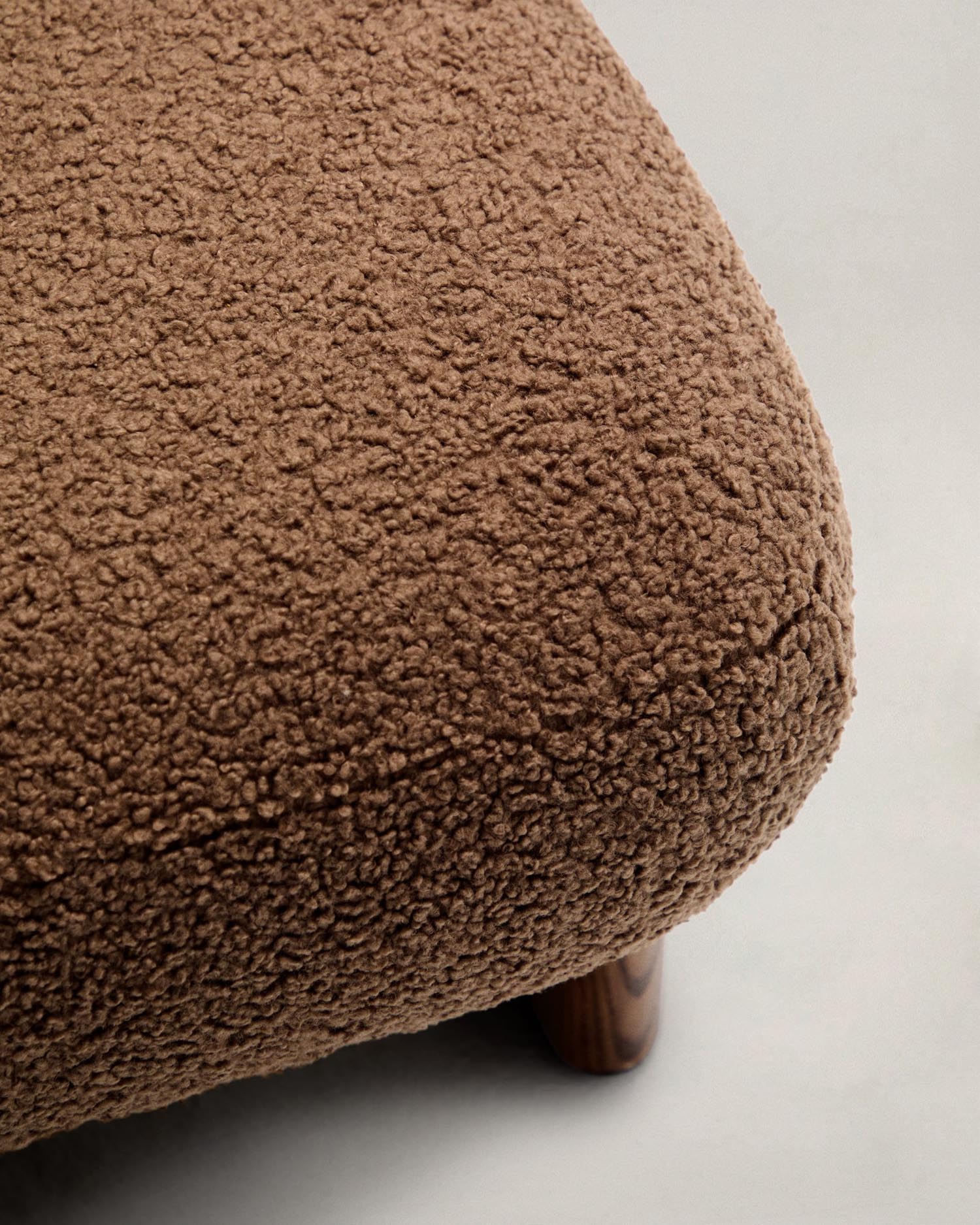 Stilvolle Fußstütze mit taupefarbenem Bouclé-Stoff, Eschenholzbeinen in Walnussoptik, FSC-zertifiziert, Maße: 65x55,4 cm.