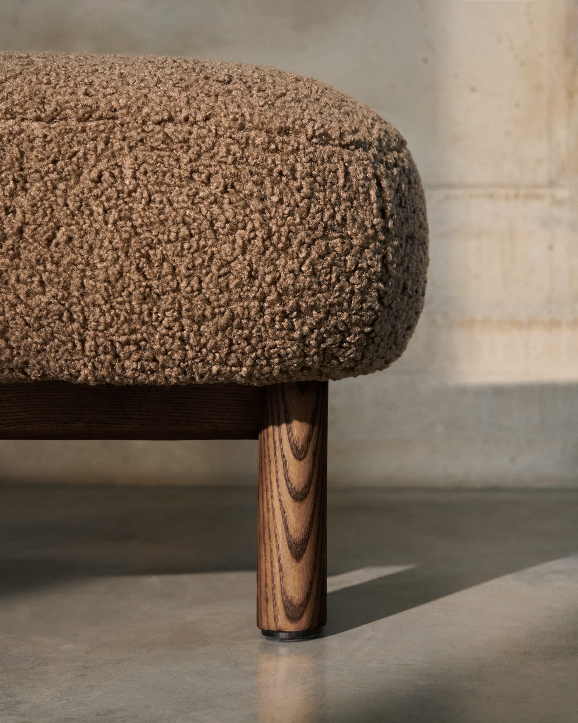 Stilvolle Fußstütze mit taupefarbenem Bouclé-Stoff, Eschenholzbeinen in Walnussoptik, FSC-zertifiziert, Maße 65x55,4 cm, von Kave Home.