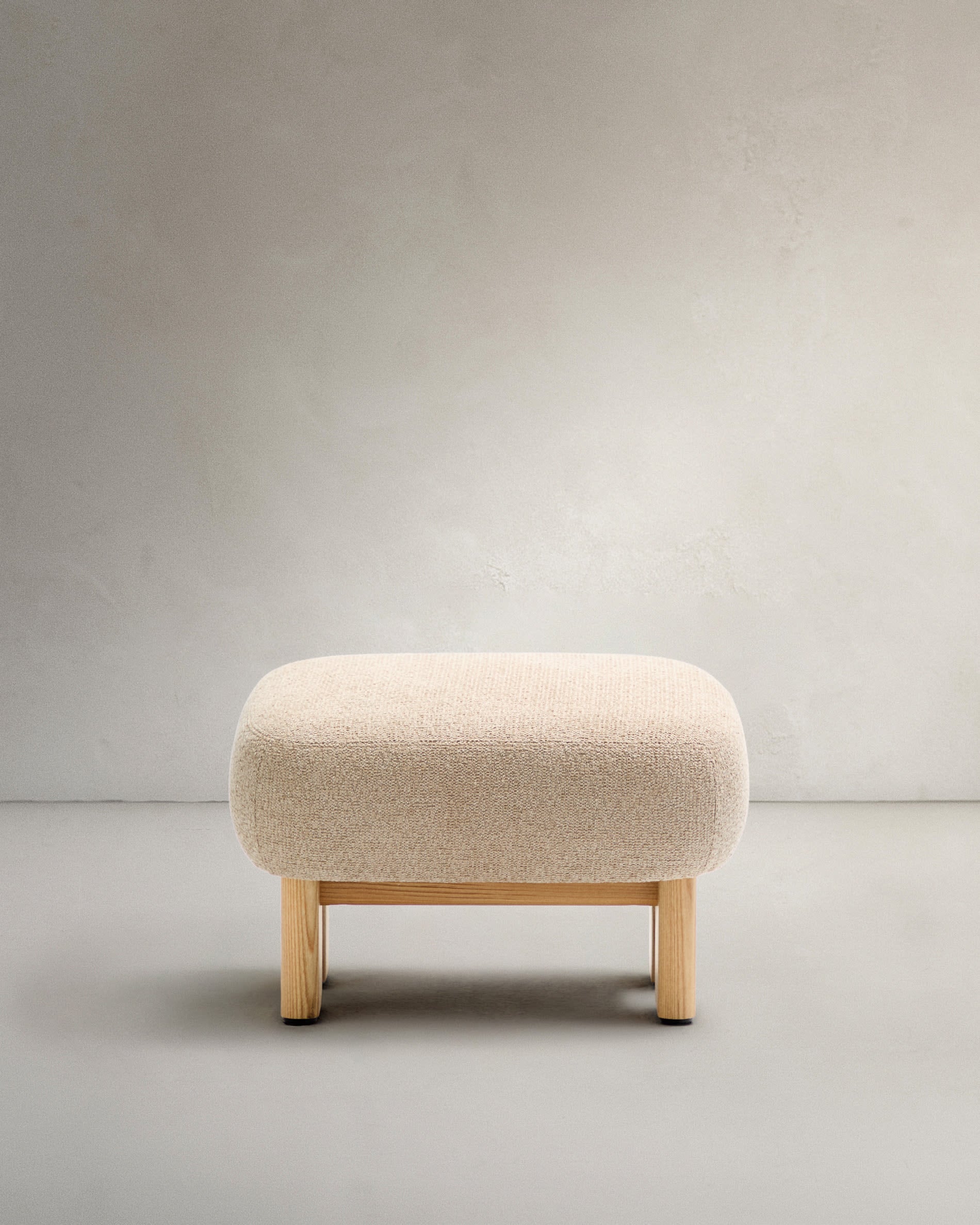 Stilvolle Fußstütze aus beigem Chenille, Beine aus Eschenholz mit natürlichem Finish, FSC-zertifiziert, Maße 65x55,4cm, von Kave Home.