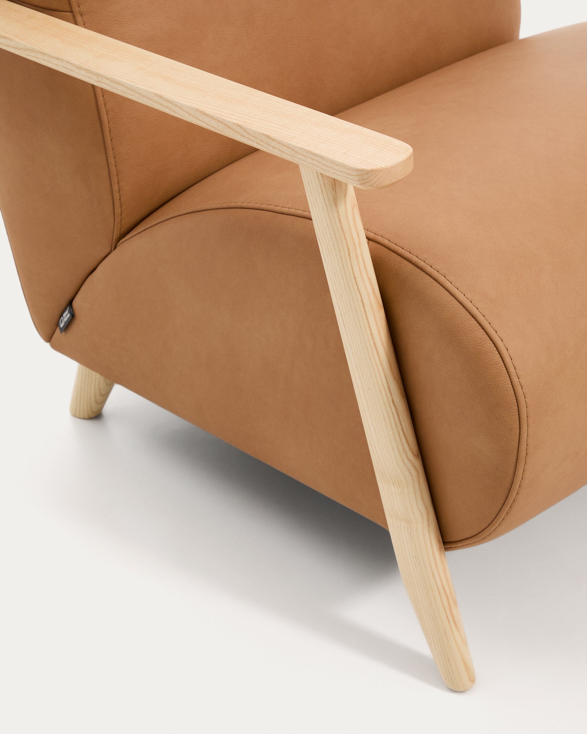 Stilvoller Sessel Meghan in braunem Leder, kombiniert mit massivem Eschenholz, perfekt für gemütliche und moderne Wohnambiente.