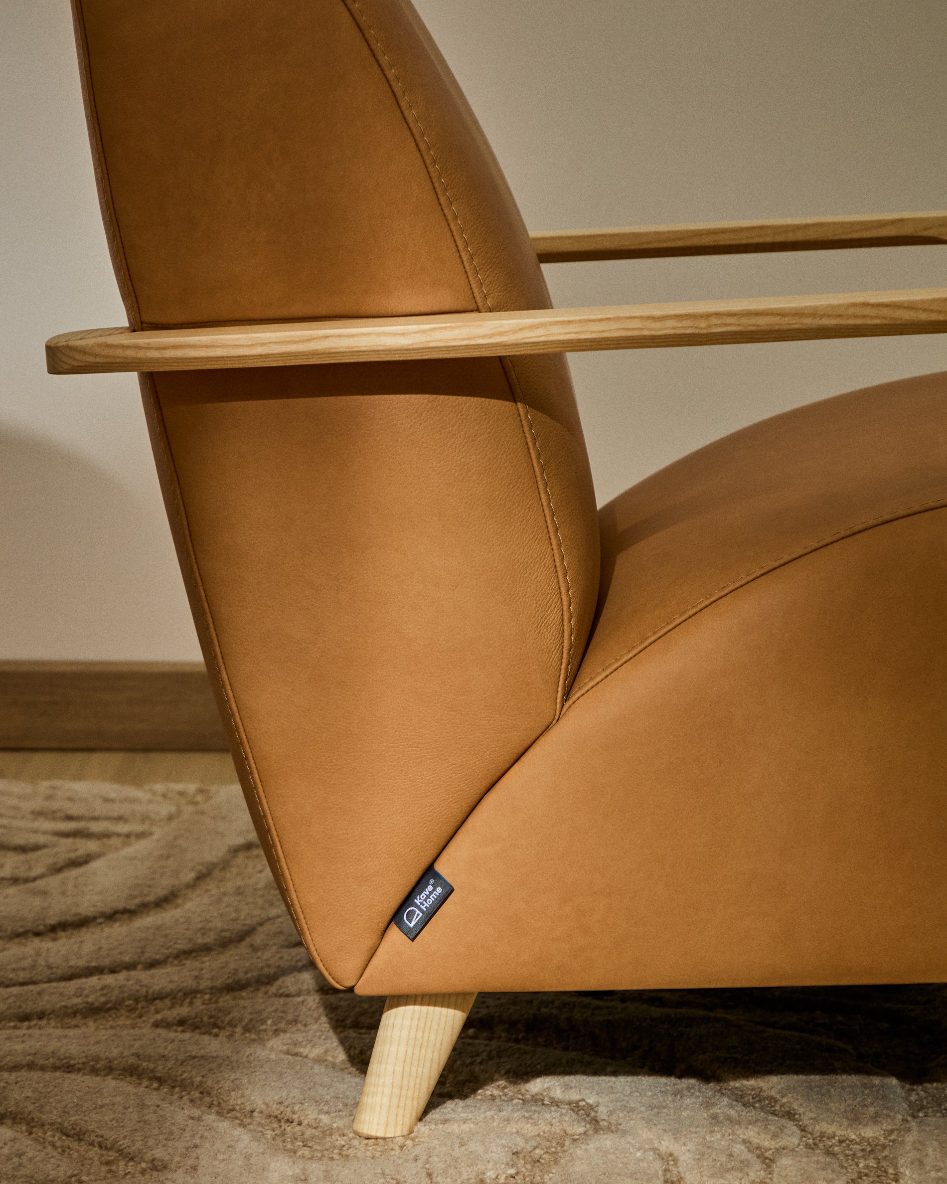 Stilvoller Sessel Meghan in braunem Leder, kombiniert mit massivem Eschenholz in Naturfarbe, perfekt für moderne Wohnkonzepte.