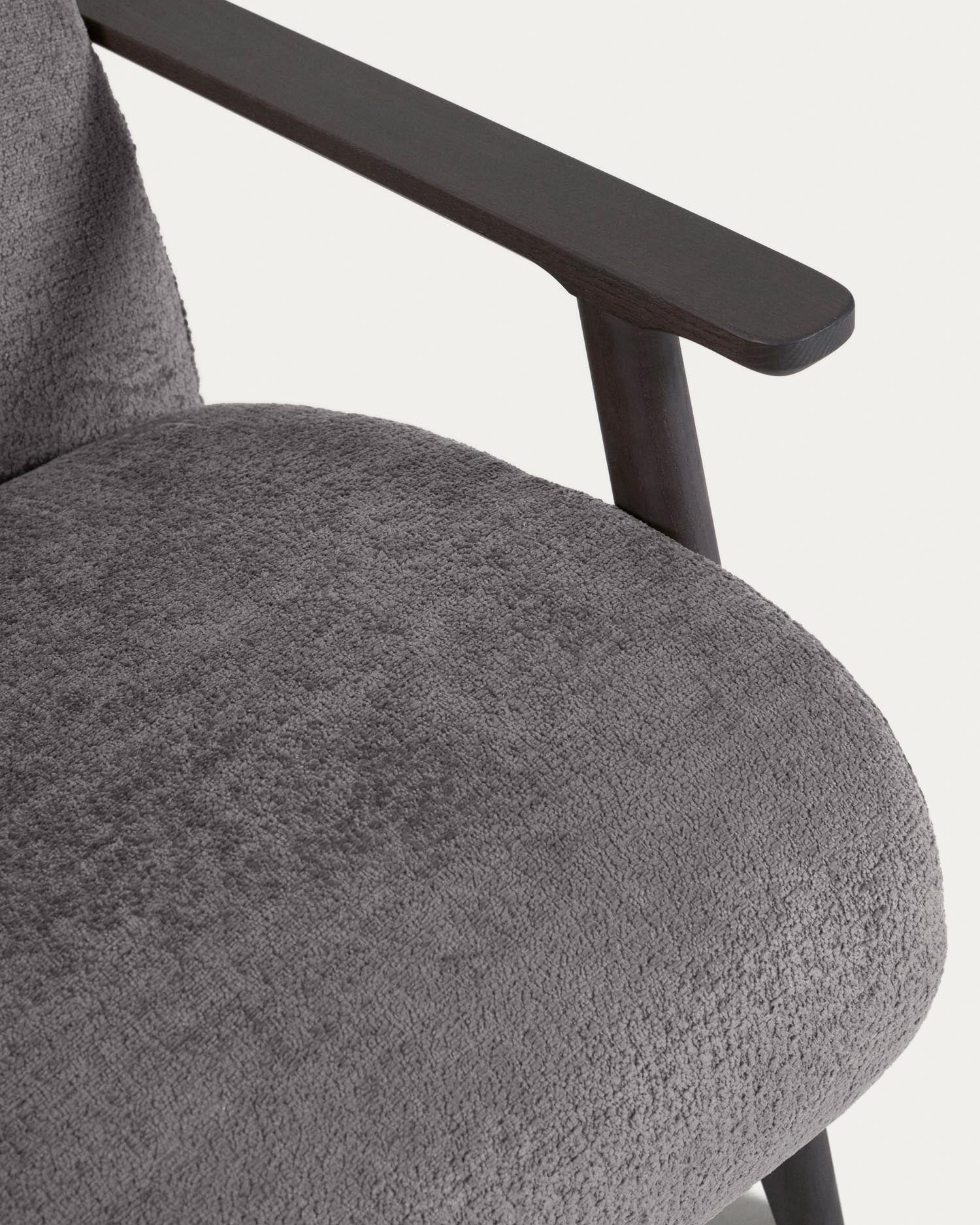 Erleben Sie den Sessel Meghan von Kave Home: Graue Chenille und massives Eschenholz mit Wenge-Finish vereinen sich zu einem stilvollen Möbelstück.