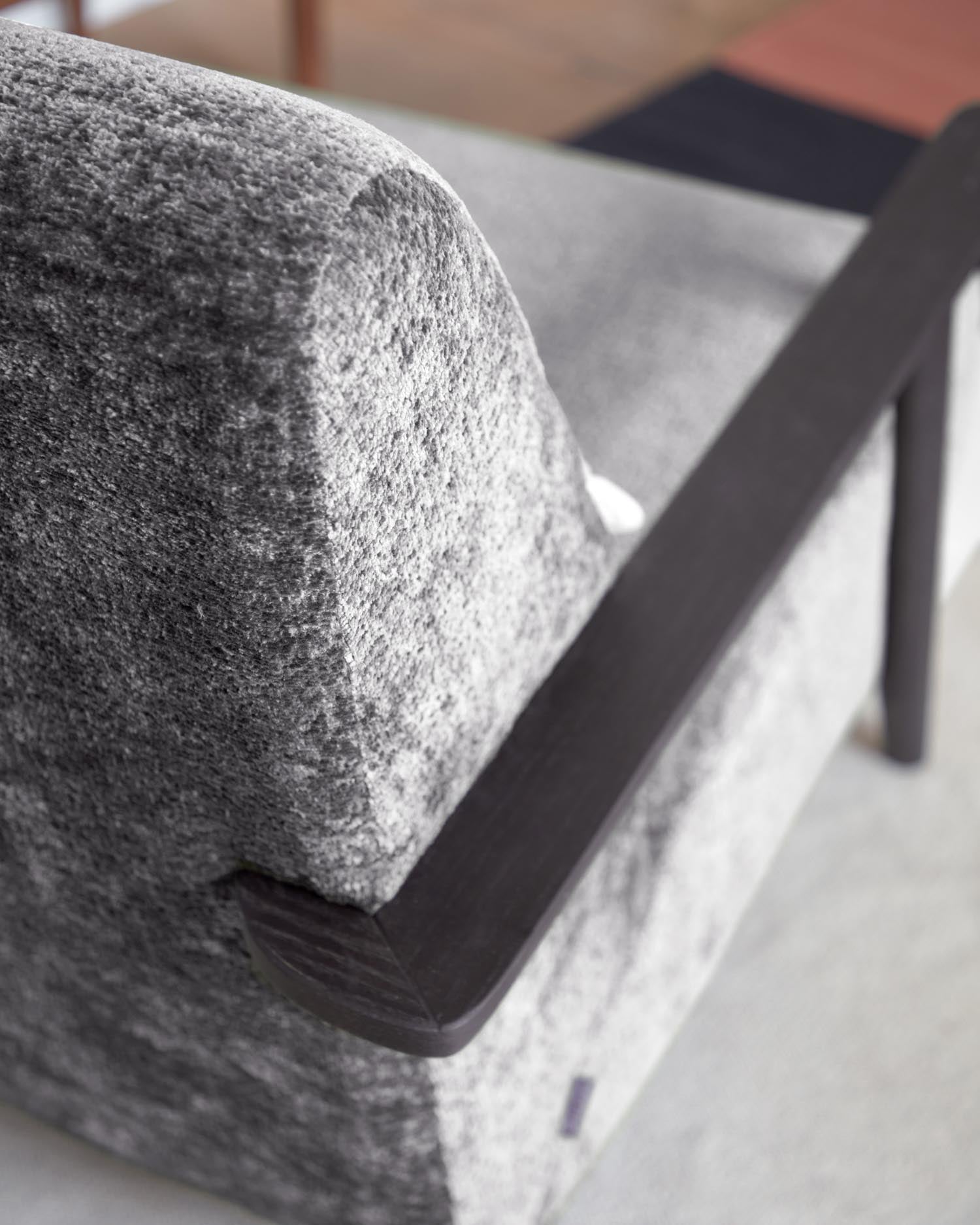 Erleben Sie den Sessel Meghan von Kave Home: Graue Chenille und massives Eschenholz mit Wenge-Finish vereinen Stil und Komfort für Ihr Zuhause.