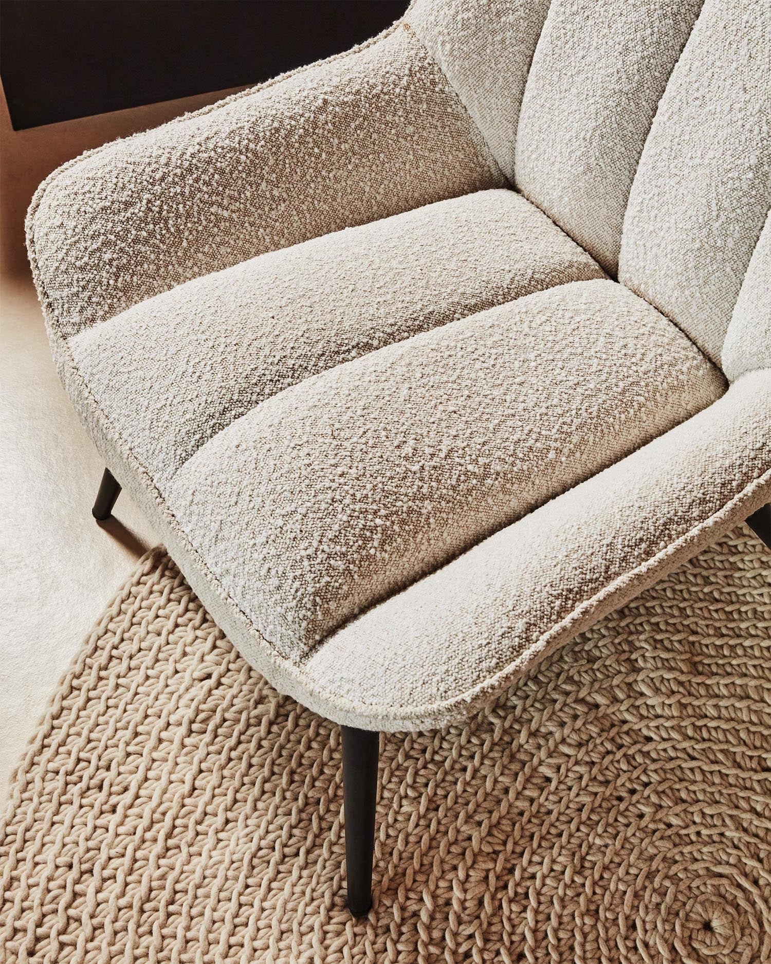 Eleganter Marlina Sessel mit weißem Bouclé-Bezug und schwarzen Stahlbeinen, ideal für modernes Wohndesign.