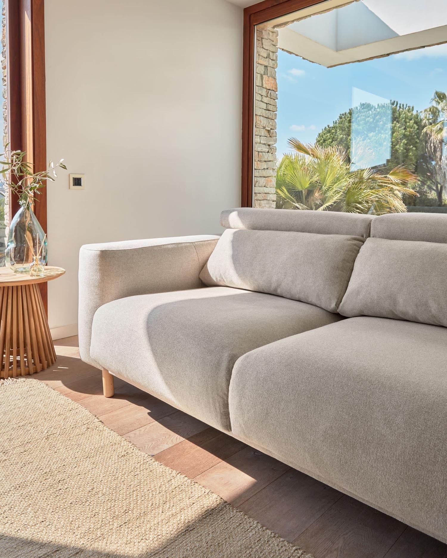 Das Singa 3-Sitzer Sofa in Beige mit verstellbaren Kopfstützen, ausziehbarem Sitz und FSC-zertifiziertem Holz vereint Komfort und Eleganz.