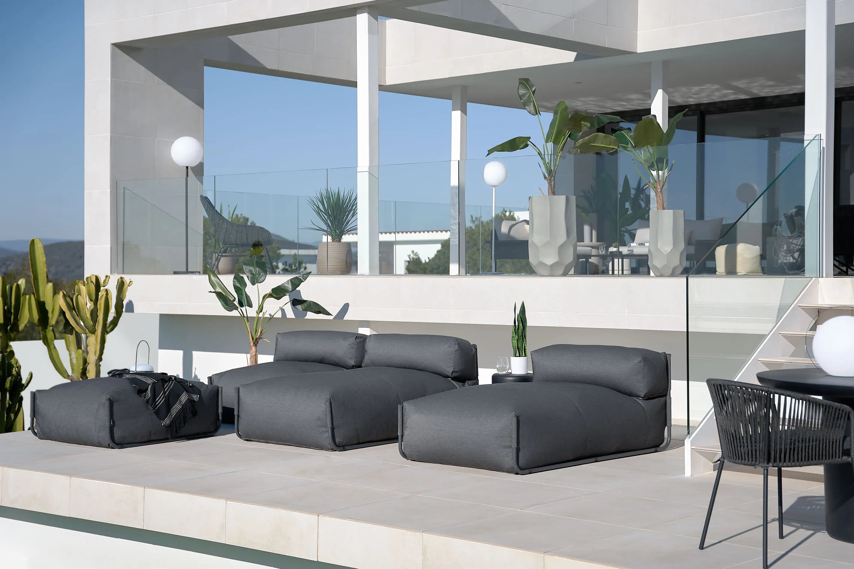 Elegantes modulares Outdoor-Sofa mit Rückenlehne, dunkelgrauem Stoff und schwarzem Aluminiumrahmen, 165x101cm, robust und modern.