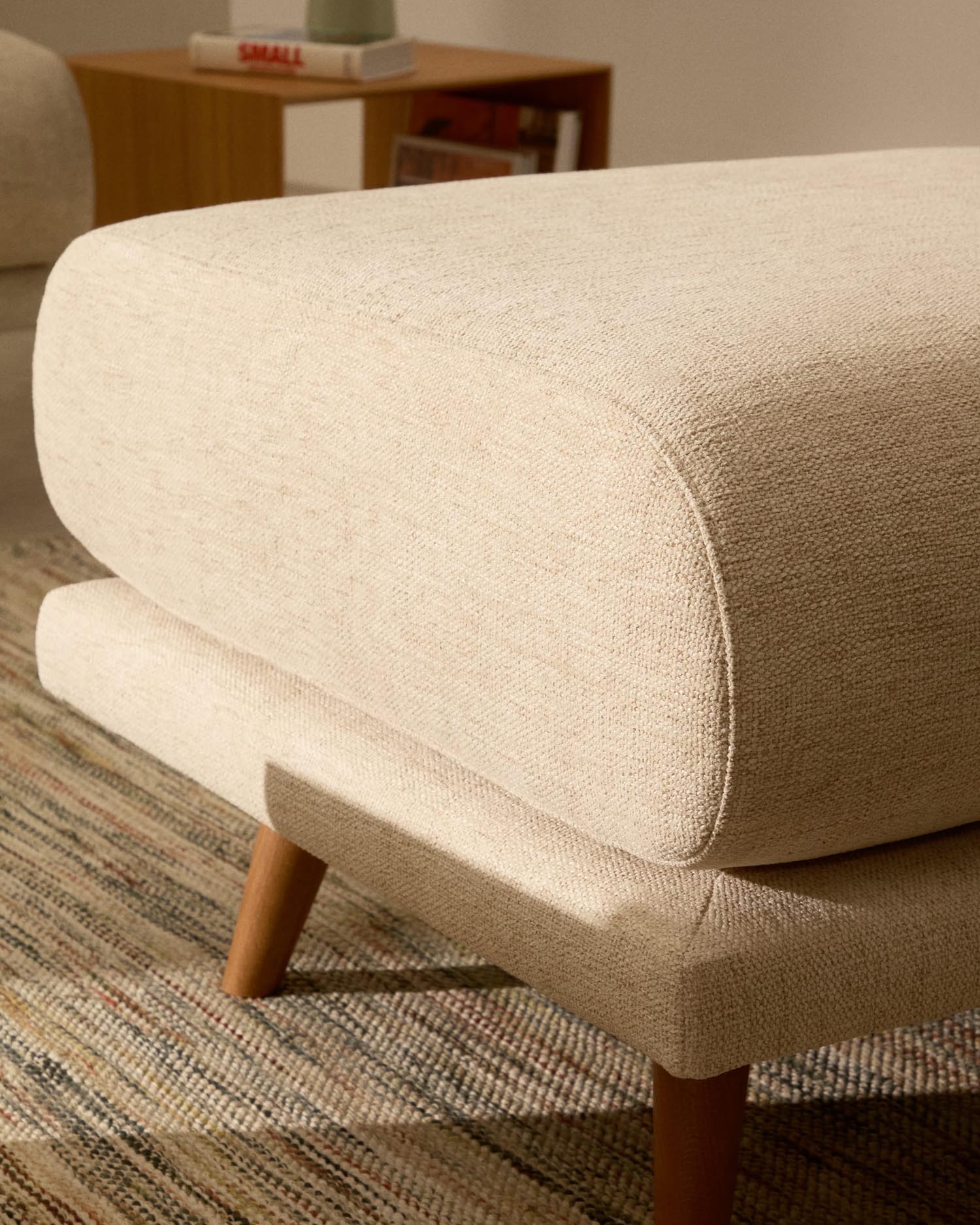 Beige Fußablage aus Chenille mit robusten Buchenholzbeinen, 90 x 70 cm. Perfekt für stilvolle Akzente und hohen Sitzkomfort.
