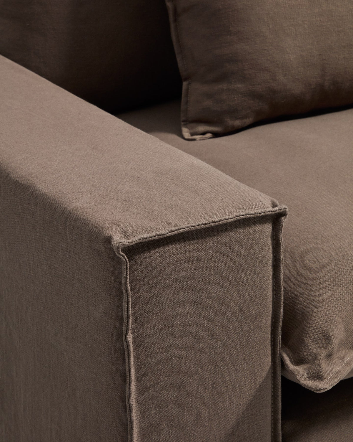 Sessel Anarela mit abnehmbarem Leinenbezug in Taupe, schwarzen Kunststoffbeinen und gepolsterter Sitzfläche, Frontalansicht.