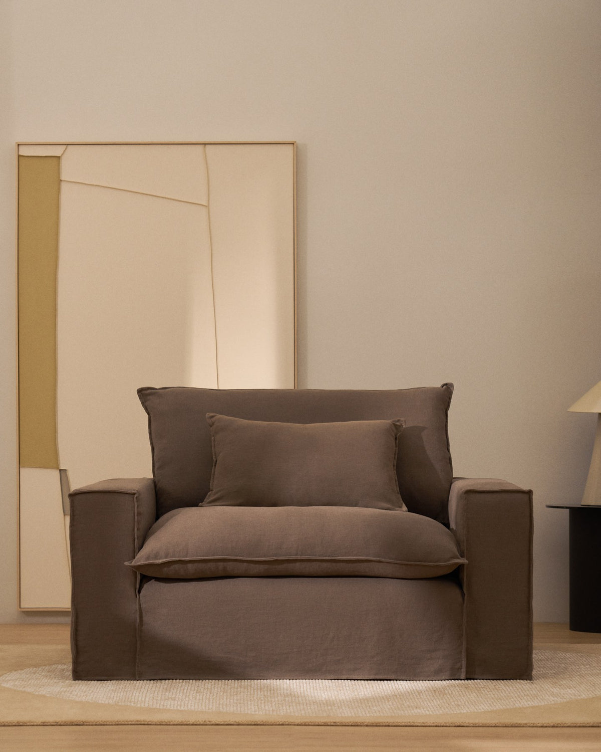 Sessel Anarela von Kave Home in Taupe mit abnehmbarem Leinenbezug, schwarzen Kunststoffbeinen und gepolsterter Sitzfläche, Breite 150 cm.