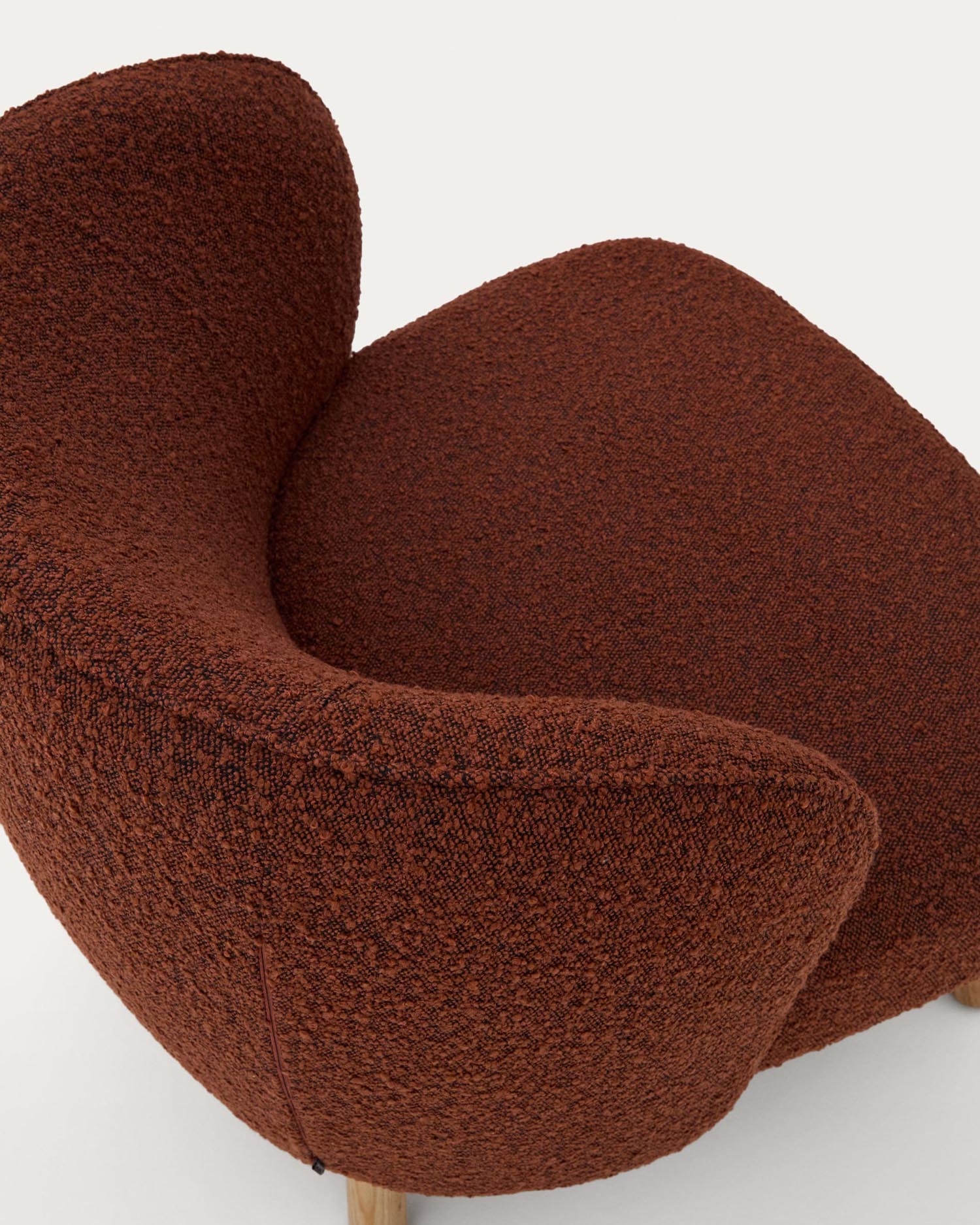 Ulit armchair made of terracotta<tc>ott</tc>a-colored sheepskin and legs made of solid beech wood with natural