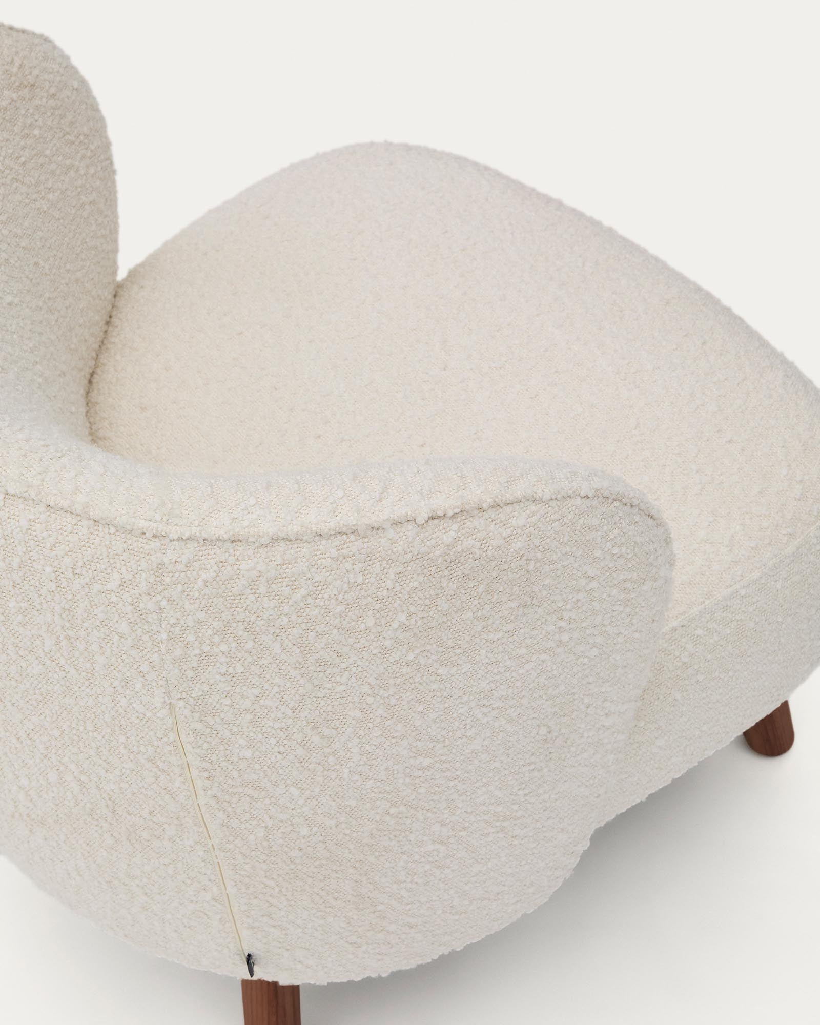 Eleganter Sessel Ulit in weichem, weißem Lammfellimitat, ausgestattet mit robusten Eschenholzbeinen in edlem Nussbaum-Finish.