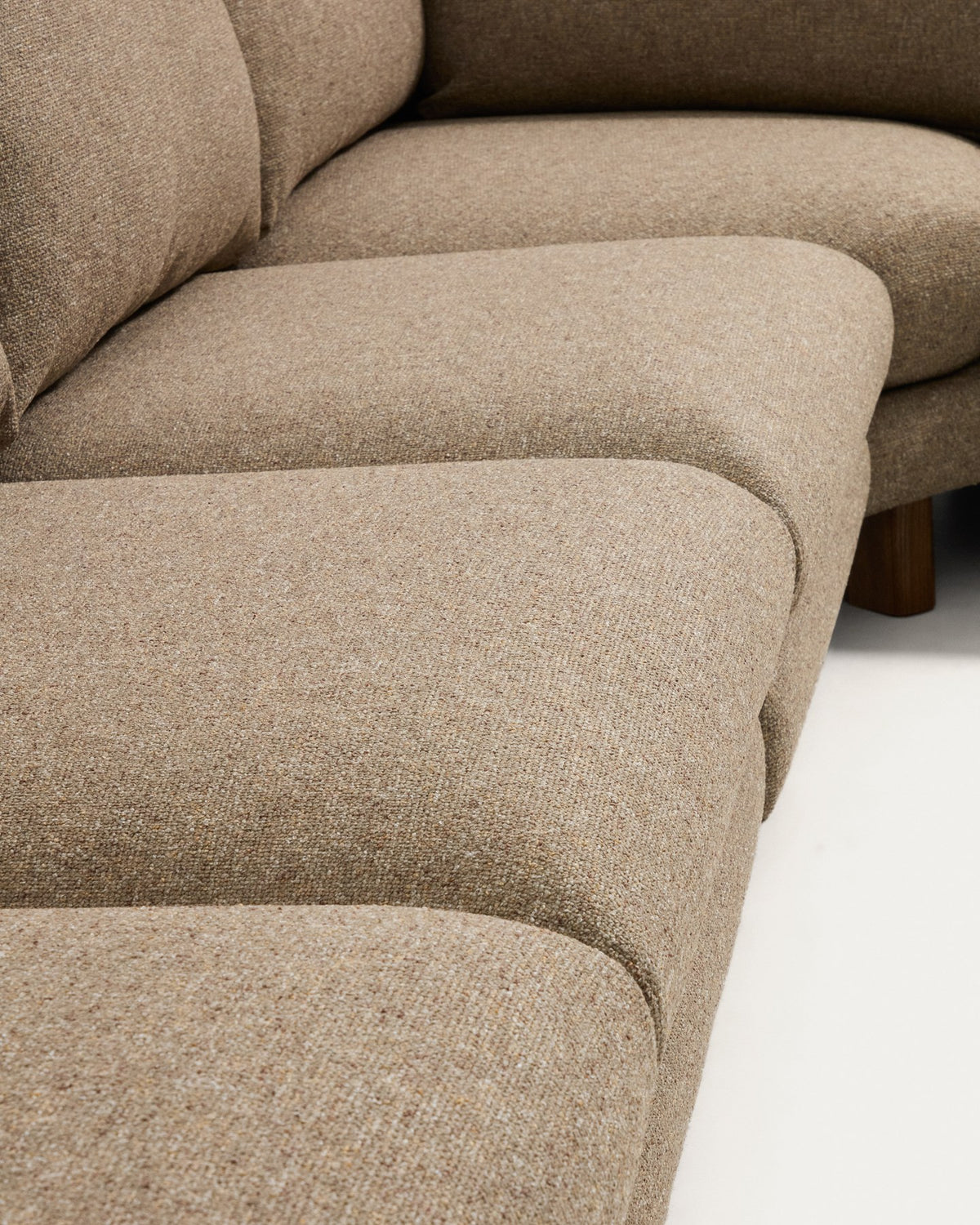 5-Sitzer Ecksofa Vera von Kave Home in Hellbraun mit Stoffbezug, geschwungenen Armlehnen und Beinen aus Eschenholz mit Nussbaum-Finish.