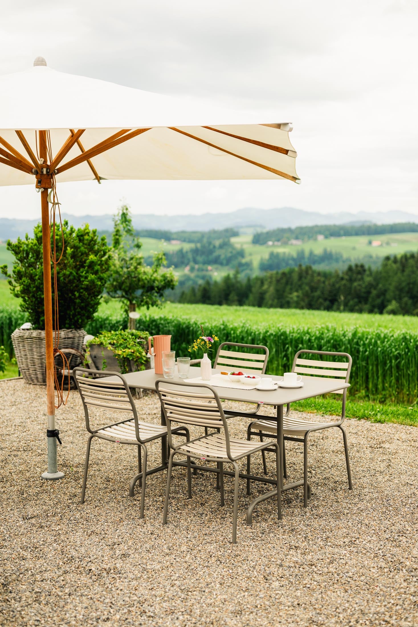 Eleganter klappbarer Metall-Gartentisch in Pastellsand, ideal für Garten und Terrasse, präsentiert in stilvollem Ambiente.