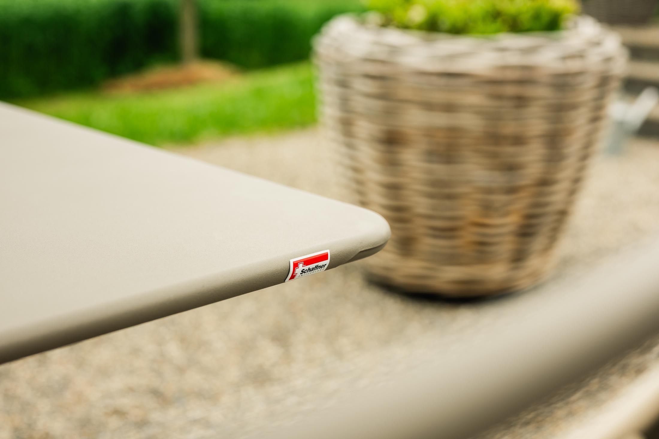 Eleganter klappbarer Metall-Gartentisch in sanften Farben, ideal für Gartenpartys oder gemütliche Abende im Freien.