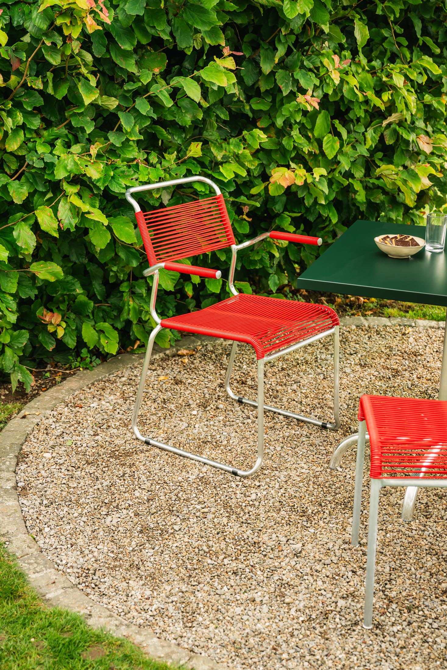Säntis Spaghetti-Gartenstuhl mit Armlehne Kufen in Rot präsentiert im Onlineshop von KAQTU Design AG. Gartenstuhl mit Armlehnen ist von Schaffner
