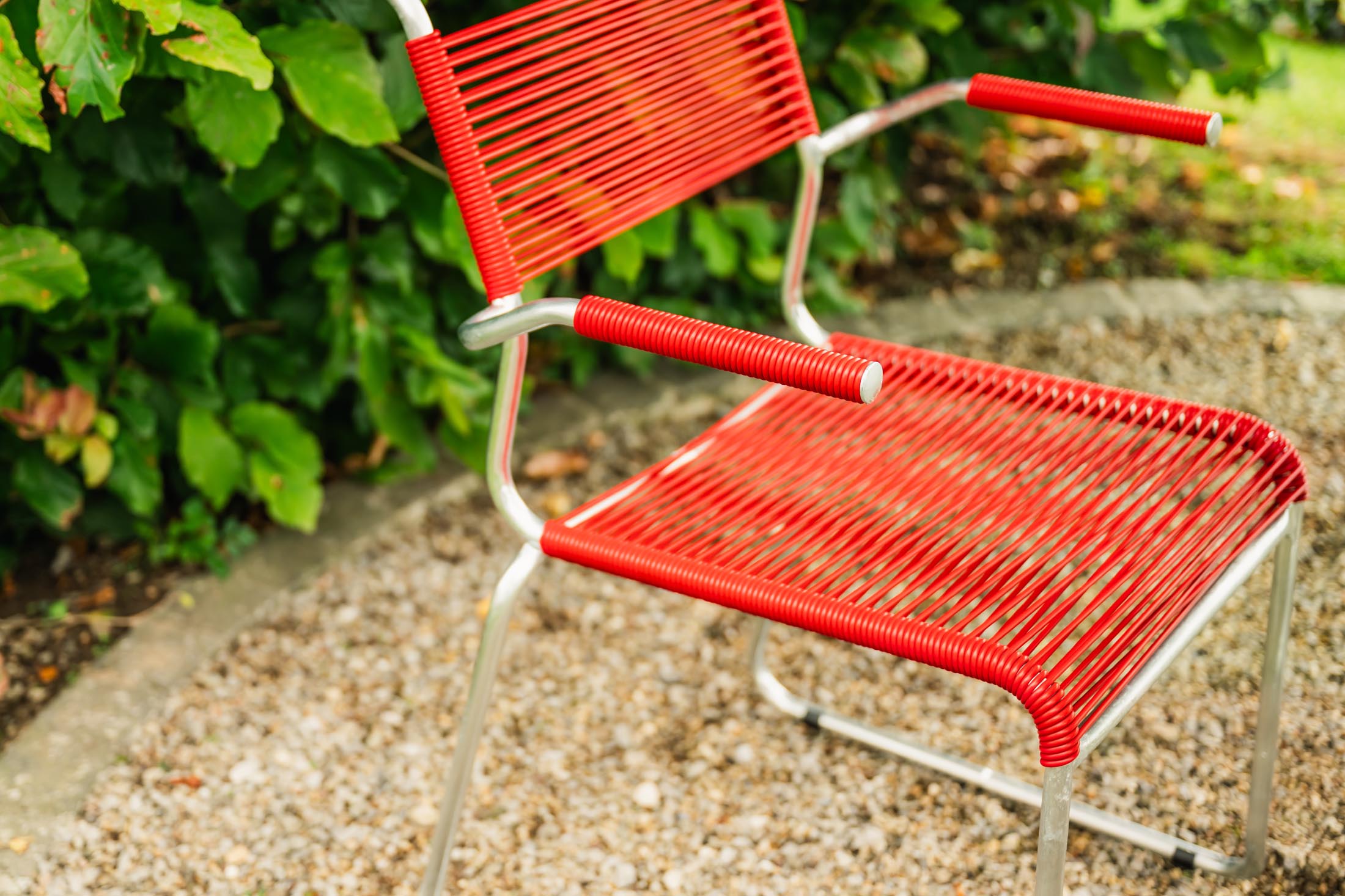 Säntis Spaghetti-Gartenstuhl mit Armlehne Kufen in Rot präsentiert im Onlineshop von KAQTU Design AG. Gartenstuhl mit Armlehnen ist von Schaffner