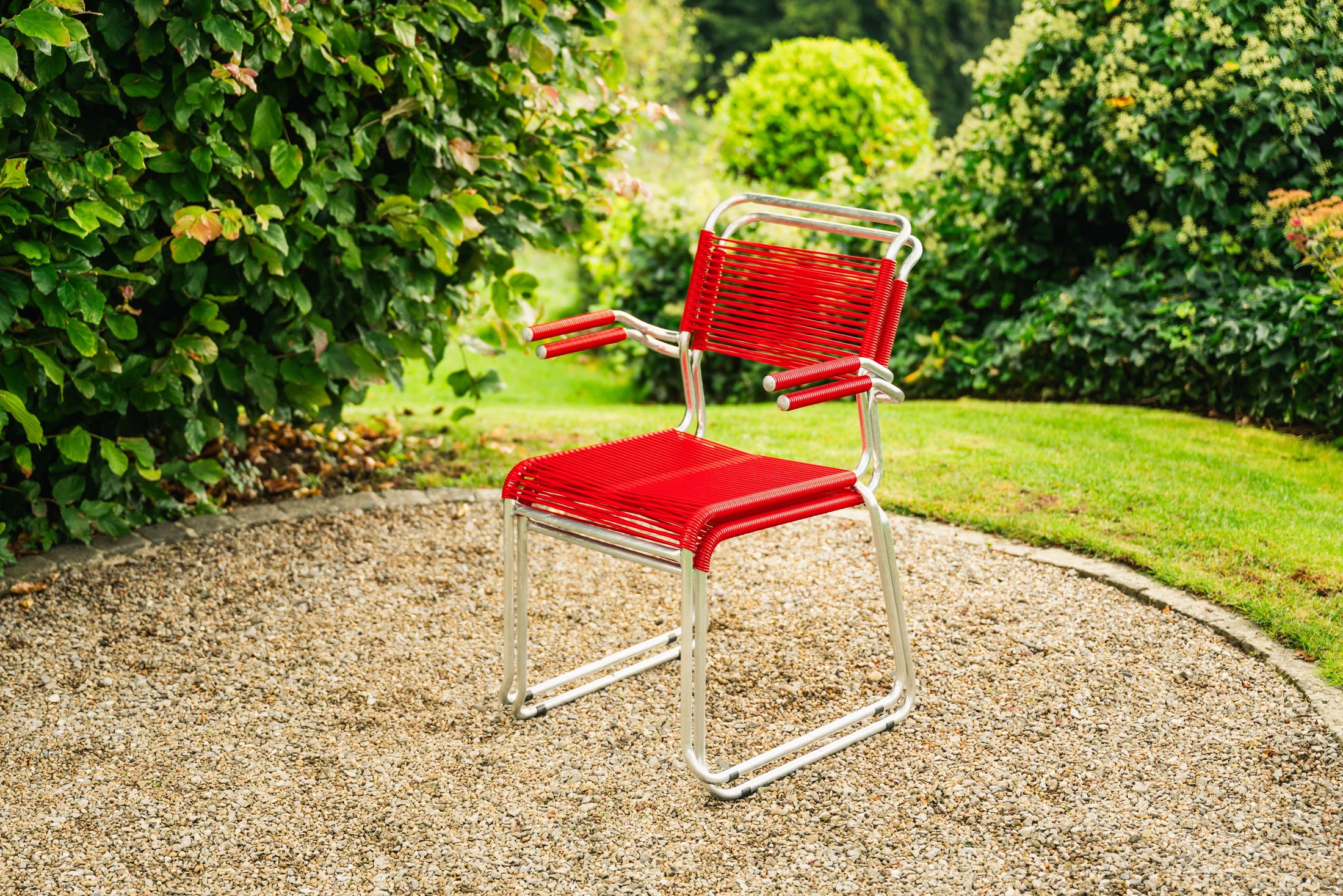 Säntis Spaghetti-Gartenstuhl mit Armlehne Kufen in Rot präsentiert im Onlineshop von KAQTU Design AG. Gartenstuhl mit Armlehnen ist von Schaffner